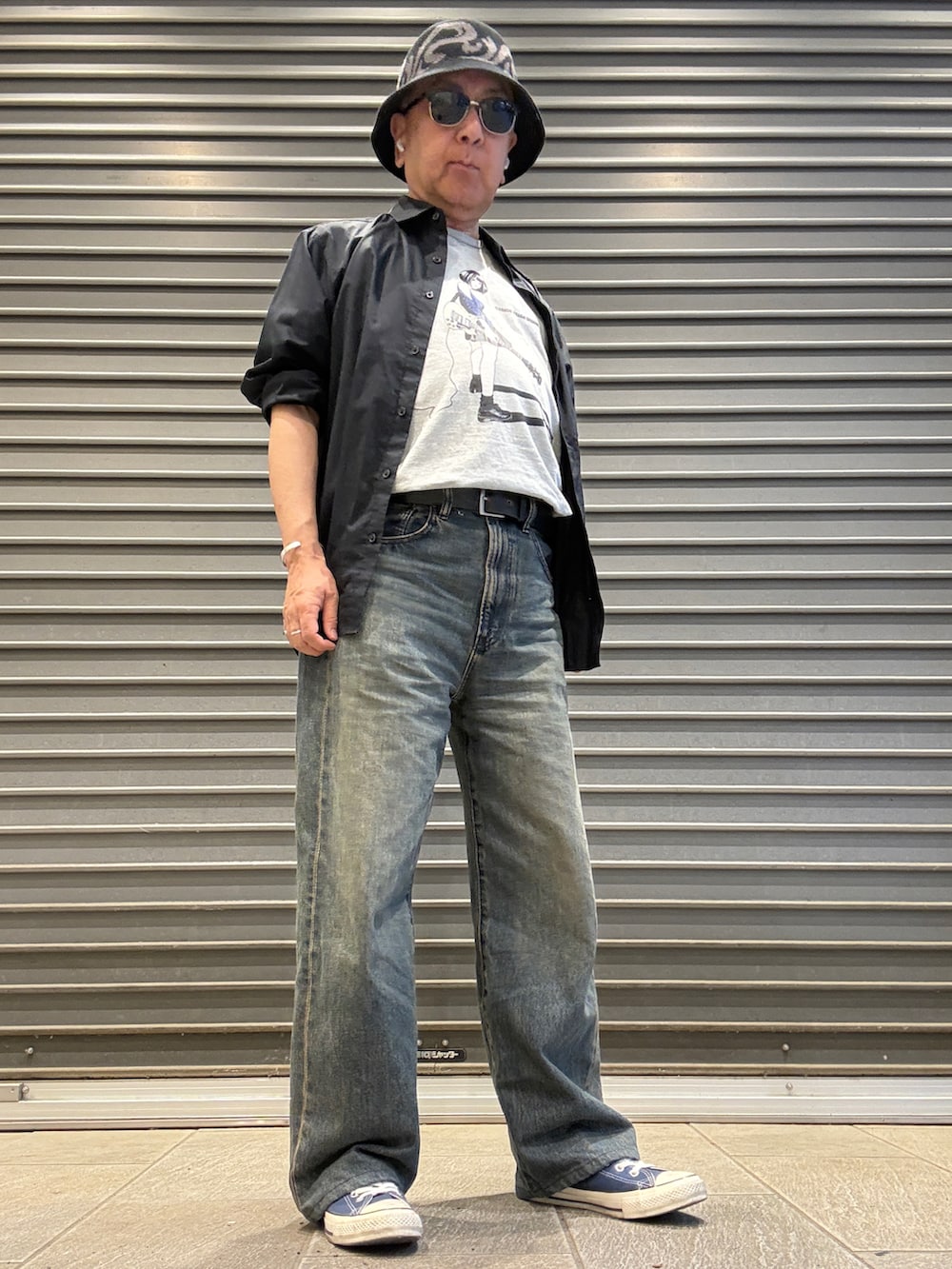 ブラック系のシャツ/ブラウス、グレー系のTシャツ/カットソー、ブルー系のデニムパンツを着用したメンズの春コーディネートの2枚目の写真