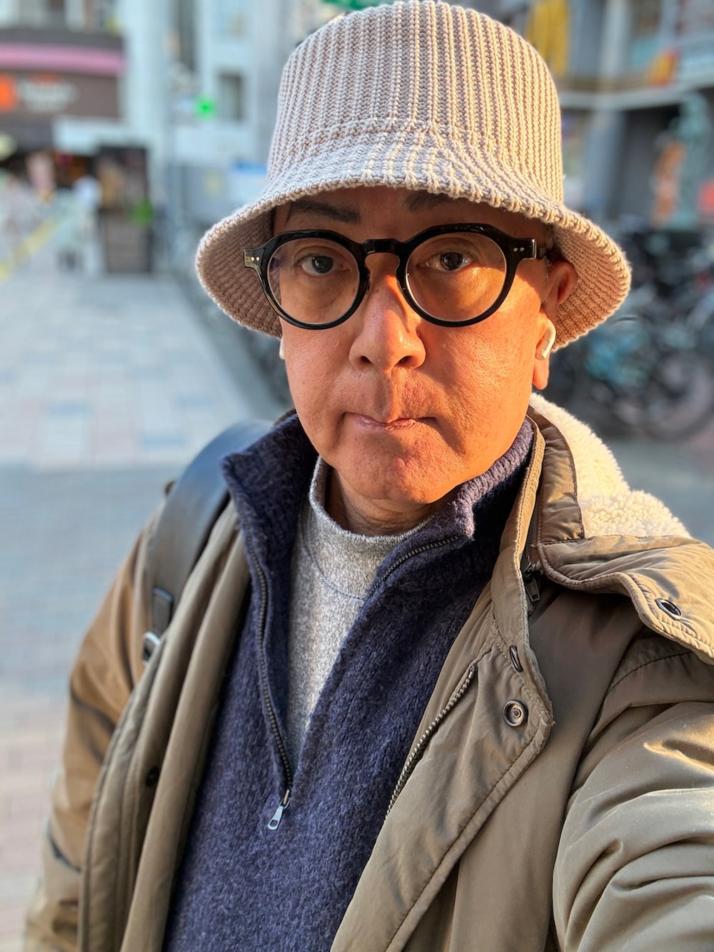 ブルー系のニット/セーター、グレー系のTシャツ/カットソー、グリーン系のモッズコートを着用したメンズの春コーディネートの2枚目の写真