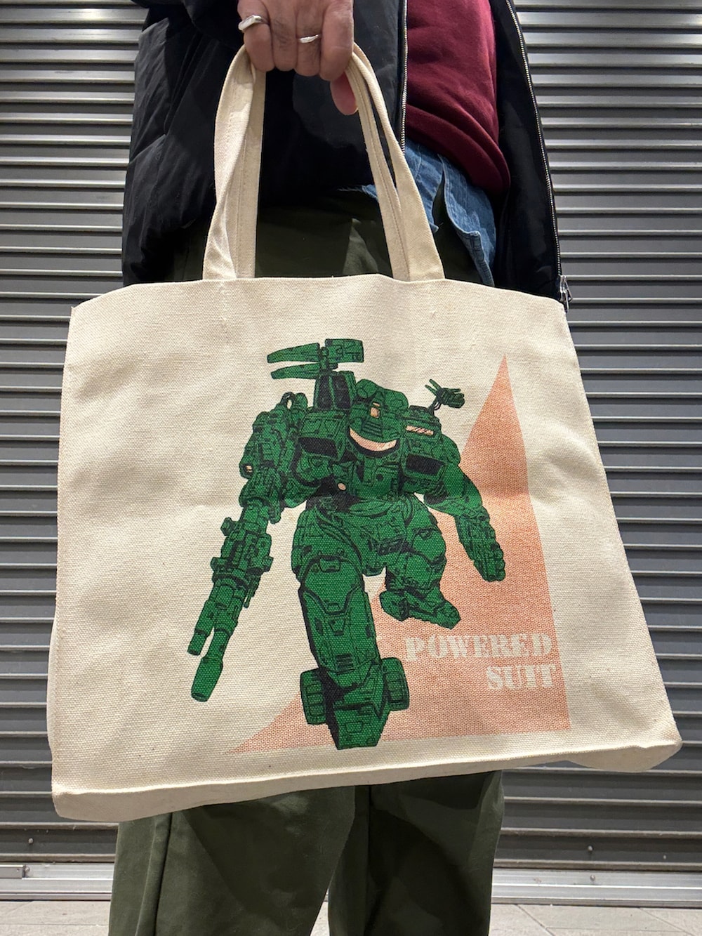 ホワイト系のトートバッグ、ブラック系のダウンジャケット/コート、レッド系のスウェットを着用したメンズの冬コーディネートの2枚目の写真