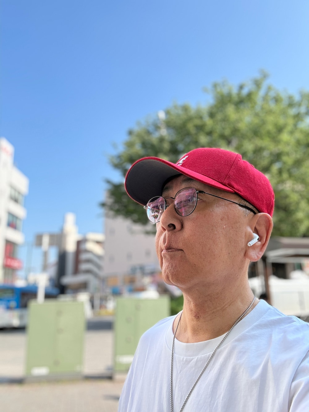 ホワイト系のTシャツ/カットソー、ブルー系のデニムパンツ、レッド系のスニーカーを着用したメンズの春コーディネートの3枚目の写真