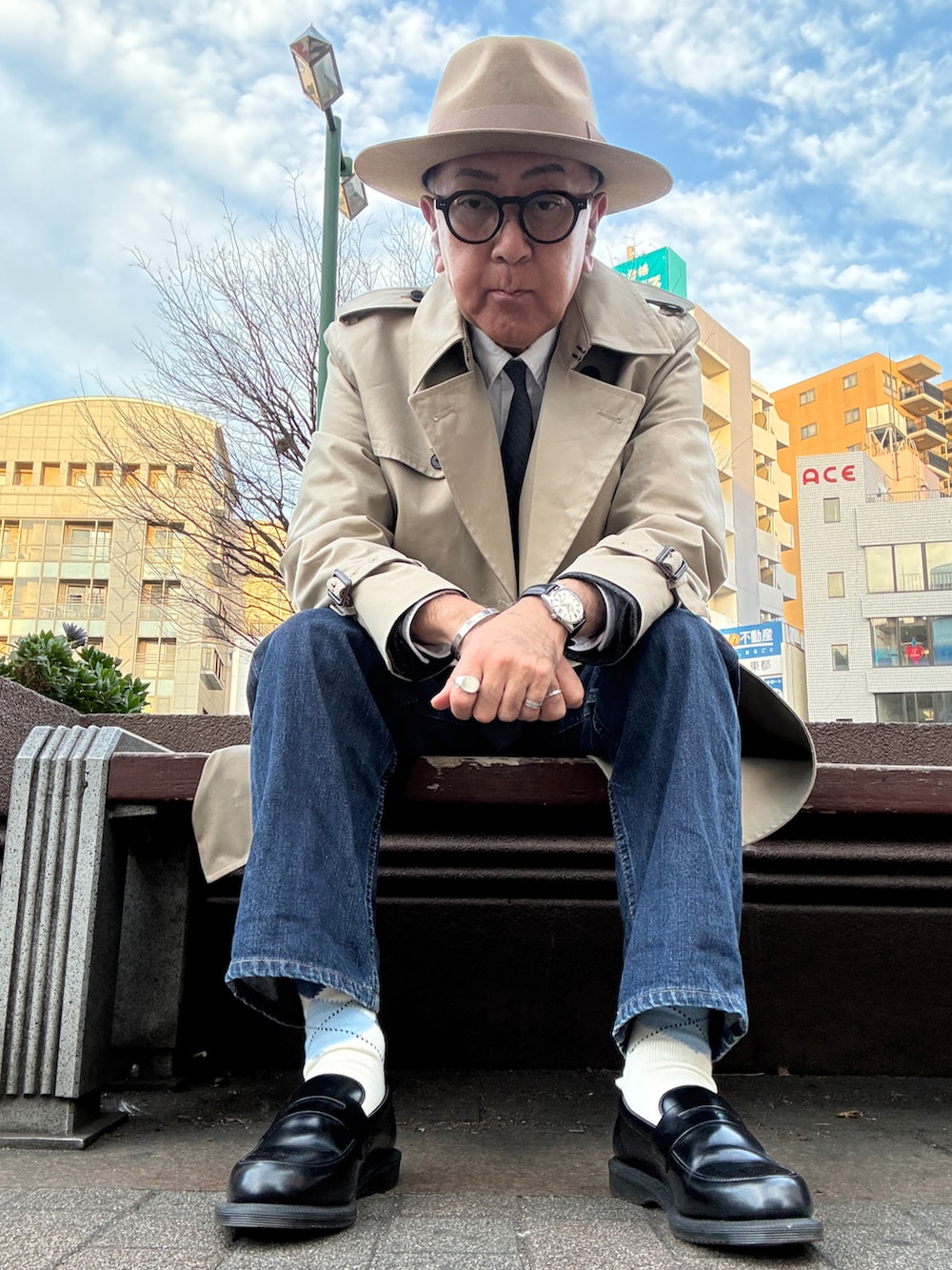 ブラック系のローファー、ホワイト系のシャツ/ブラウス、ベージュ系のトレンチコートを着用したメンズの冬コーディネートの2枚目の写真