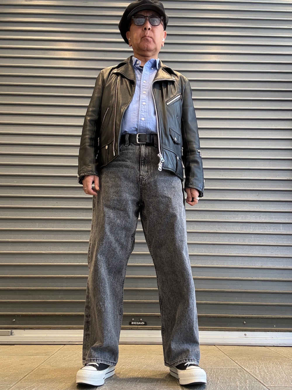 ブラック系のライダースジャケット、ブラック系のスニーカー、ブルー系のシャツ/ブラウスを着用したメンズの春コーディネートの2枚目の写真