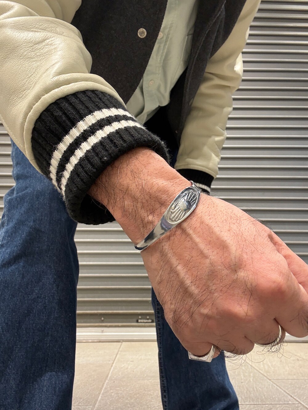 グリーン系のシャツ/ブラウス、グレー系のスタジャン、ブルー系のデニムパンツを着用したメンズの冬コーディネートの2枚目の写真