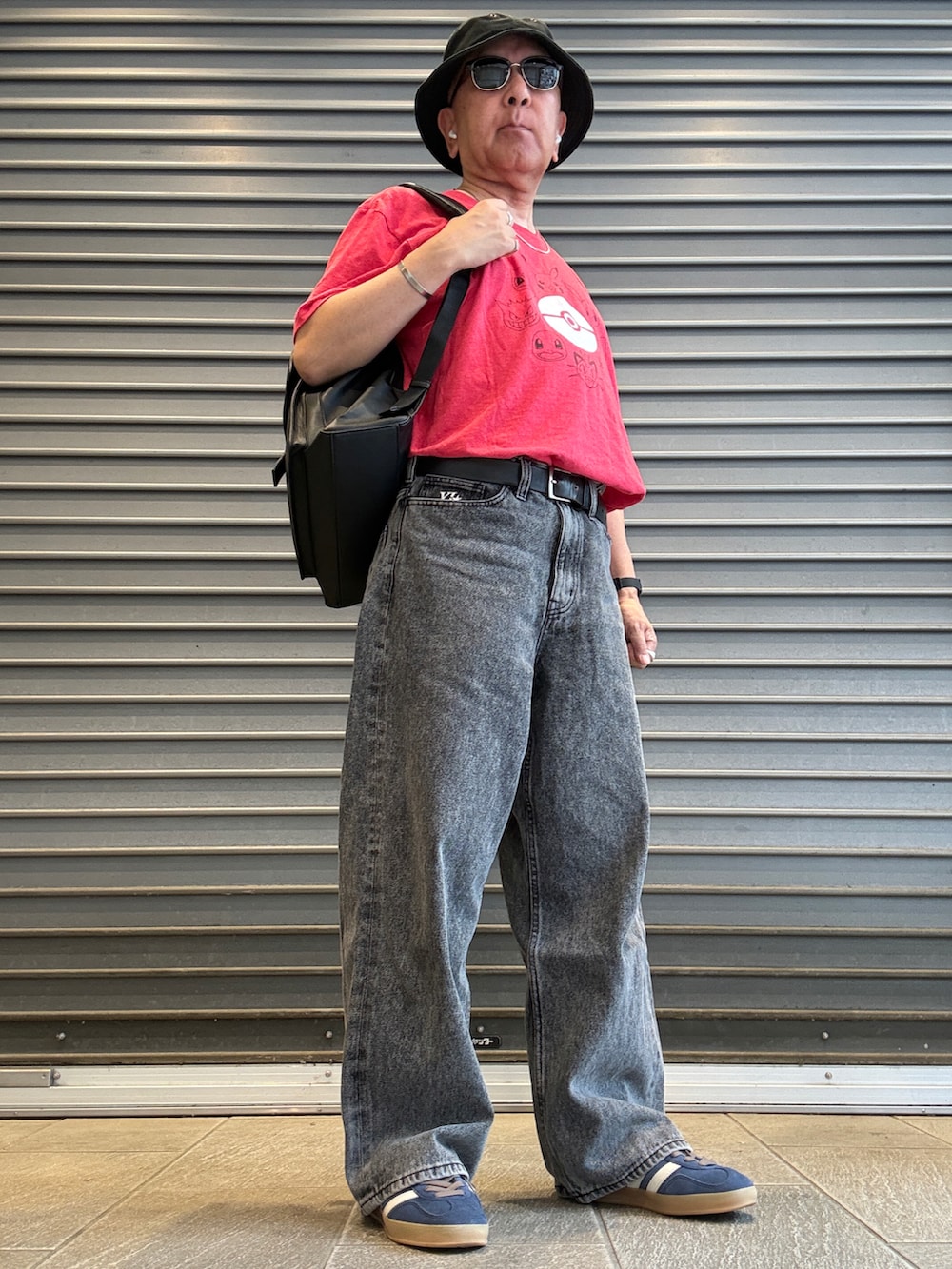 ブラック系のデニムパンツ、レッド系のTシャツ/カットソー、ブラック系のバックパック/リュックを着用したメンズの夏コーディネートの2枚目の写真