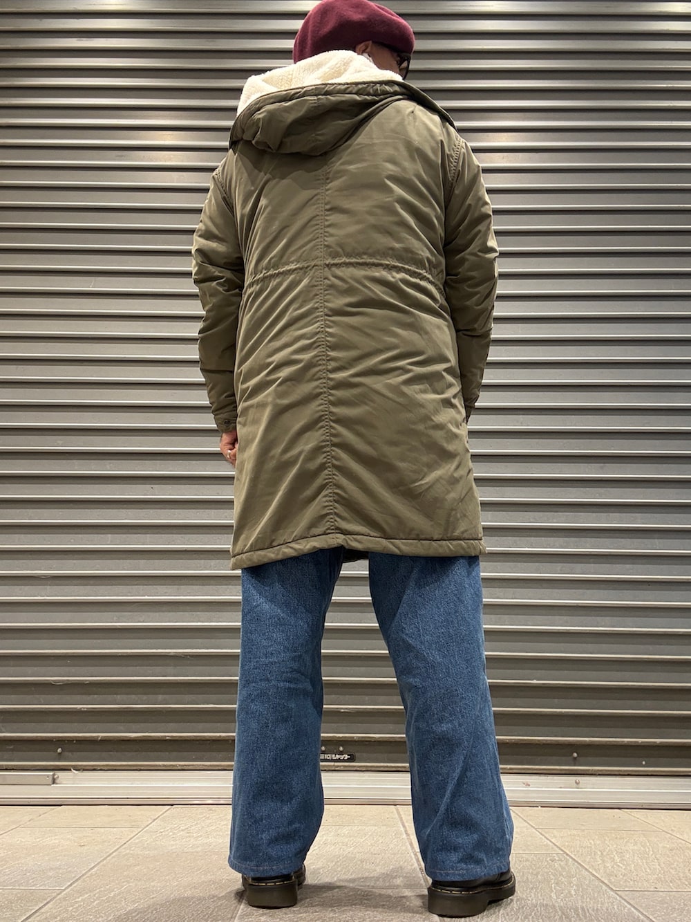 グレー系のニット/セーター、ブラック系のドレスシューズ、グリーン系のモッズコートを着用したメンズの冬コーディネートの3枚目の写真