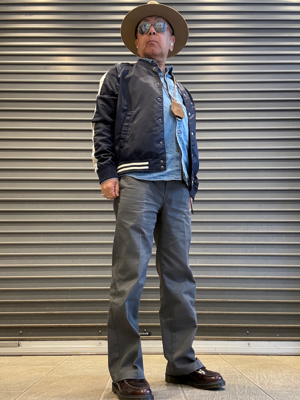 グレー系のチノパンツ、レッド系のローファー、ブルー系のシャツ/ブラウスを着用したメンズの春コーディネートの2枚目の写真