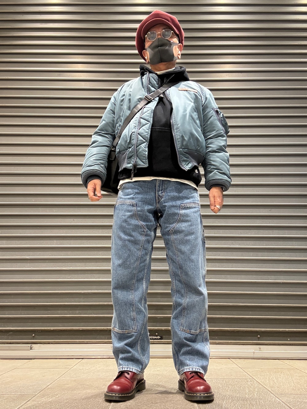 ブラック系のパーカー、レッド系のブーツ、グリーン系のMA-1を着用したメンズの春コーディネートの2枚目の写真