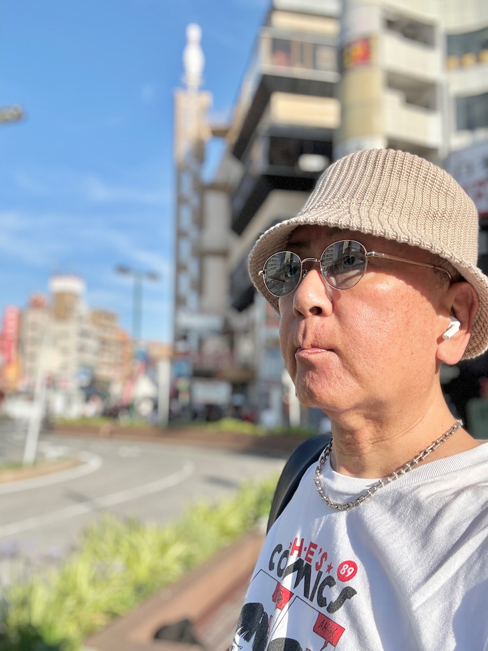 ブルー系のデニムパンツ、ホワイト系のTシャツ/カットソー、レッド系のスニーカーを着用したメンズの夏コーディネートの3枚目の写真