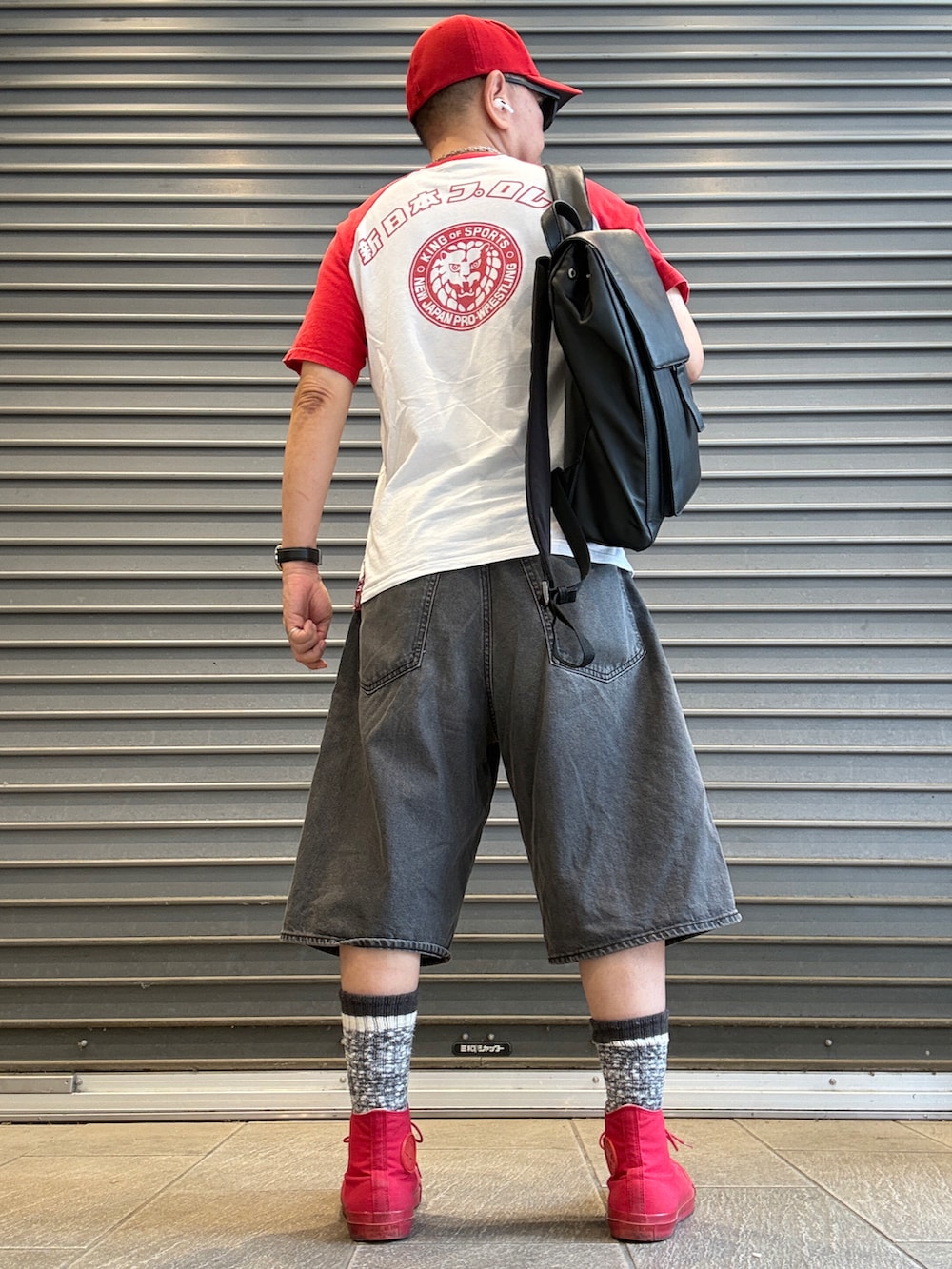 レッド系のスニーカー、ホワイト系のTシャツ/カットソー、ブラック系のバックパック/リュックを着用したメンズの夏コーディネートの2枚目の写真