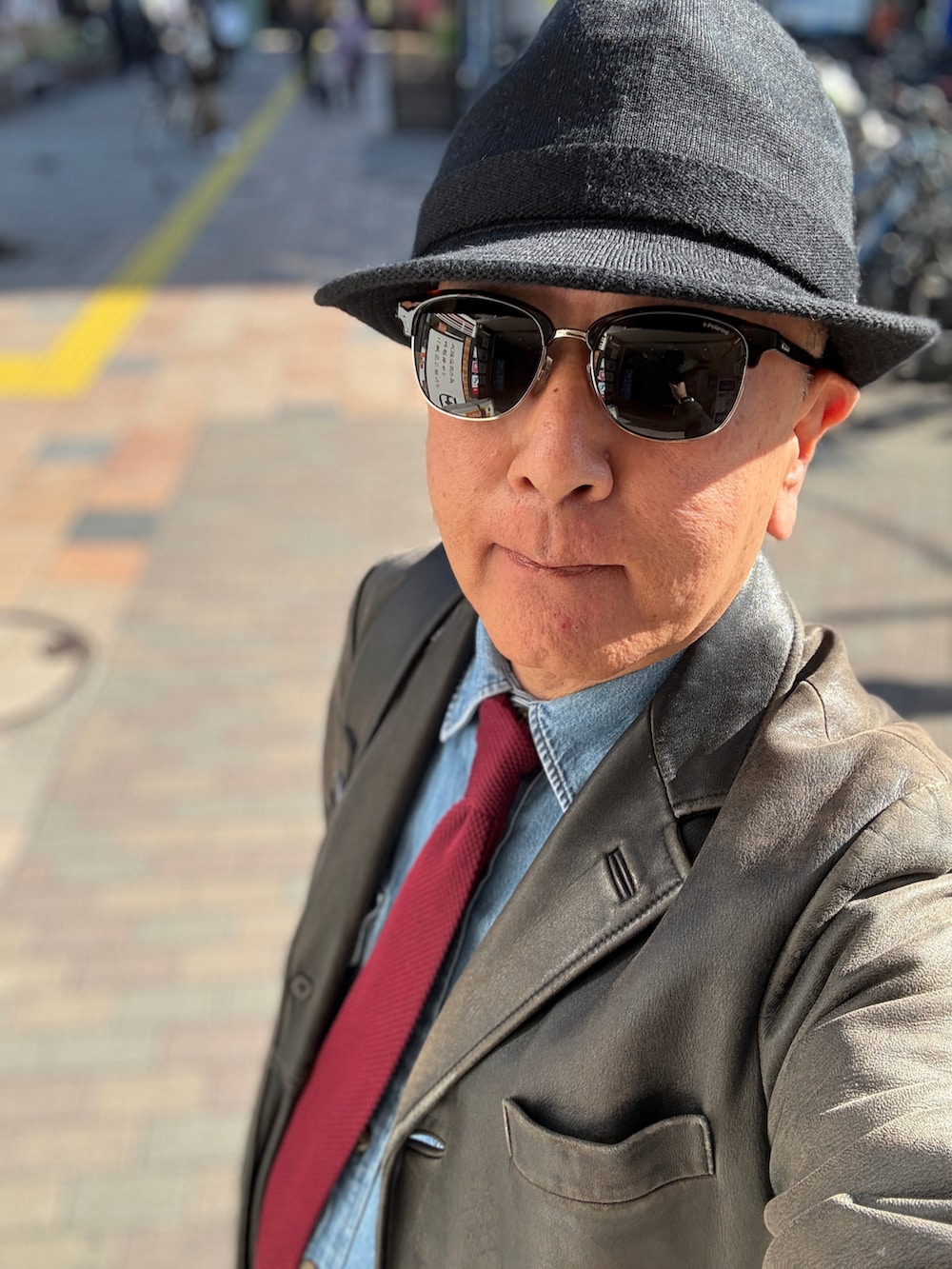 グレー系のチノパンツ、ブルー系のシャツ/ブラウス、レッド系のネクタイを着用したメンズの春コーディネートの2枚目の写真