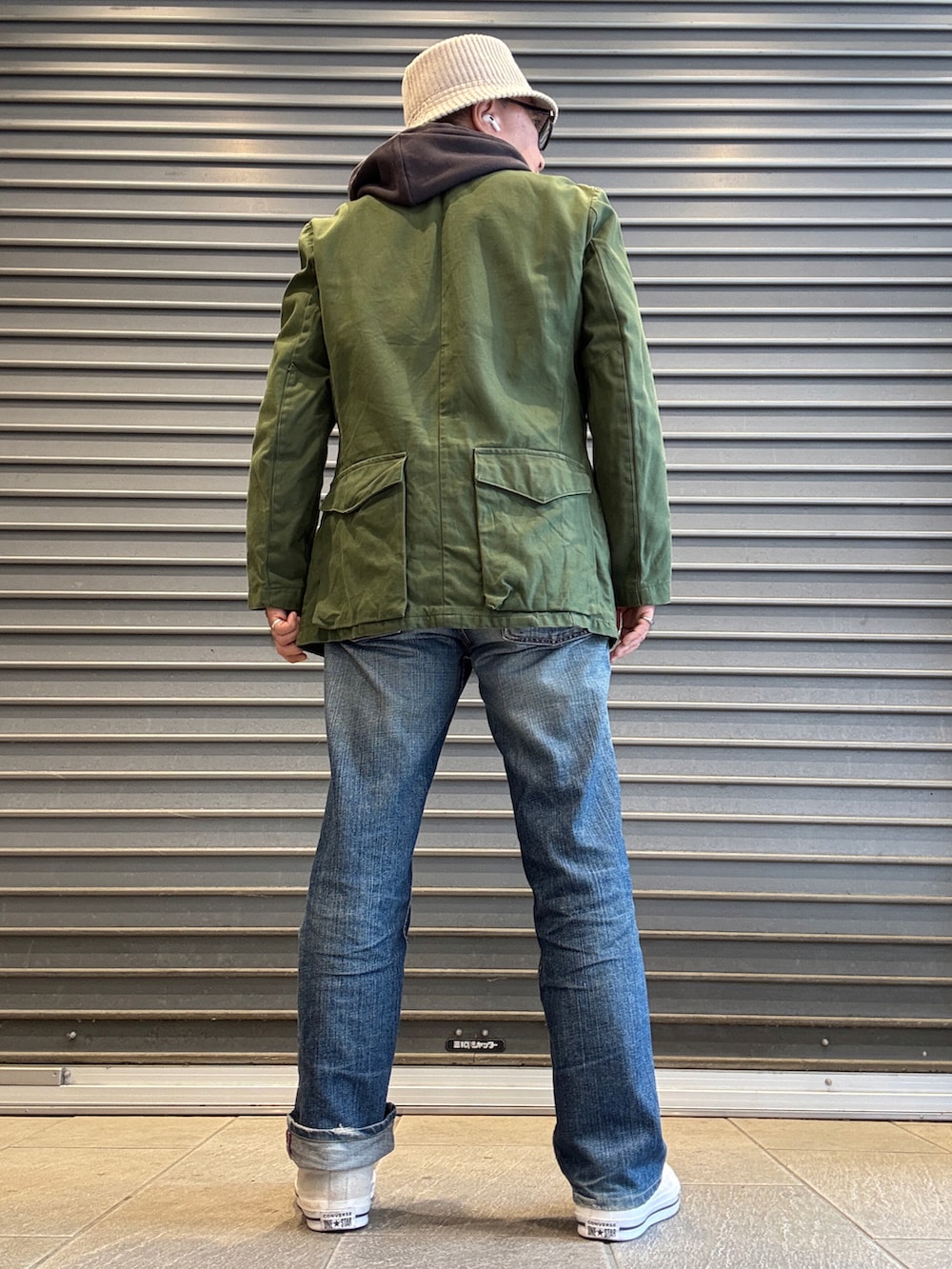 イエロー系のシャツ/ブラウス、グレー系のパーカー、グリーン系のミリタリージャケットを着用したメンズの春コーディネートの2枚目の写真