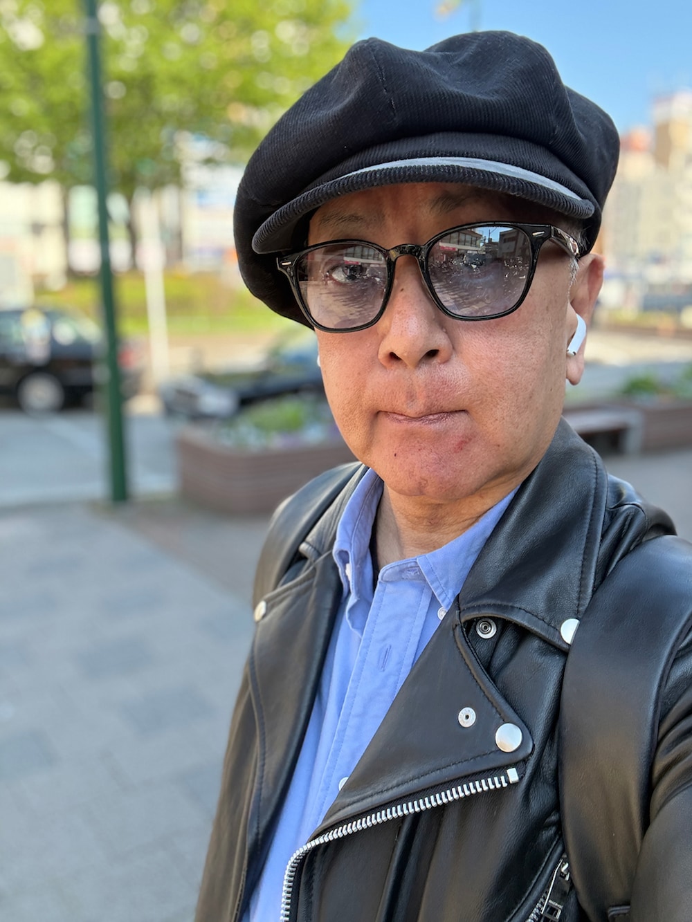 ブラック系のライダースジャケット、ブラック系のスニーカー、ブルー系のシャツ/ブラウスを着用したメンズの春コーディネートの3枚目の写真