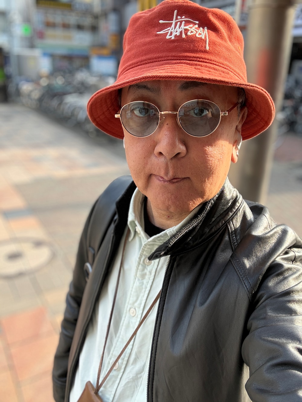 グリーン系のシャツ/ブラウス、ブラック系のライダースジャケット、ブルー系のデニムパンツを着用したメンズの春コーディネートの3枚目の写真