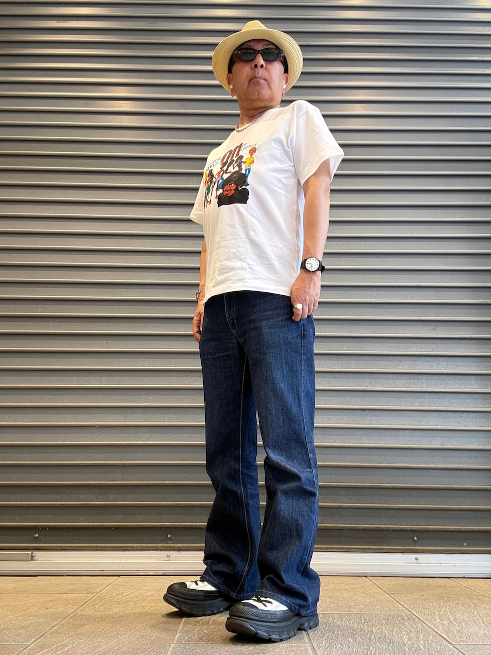ブルー系のデニムパンツ、ホワイト系のTシャツ/カットソー、ホワイト系のスニーカーを着用したメンズの春コーディネートの2枚目の写真