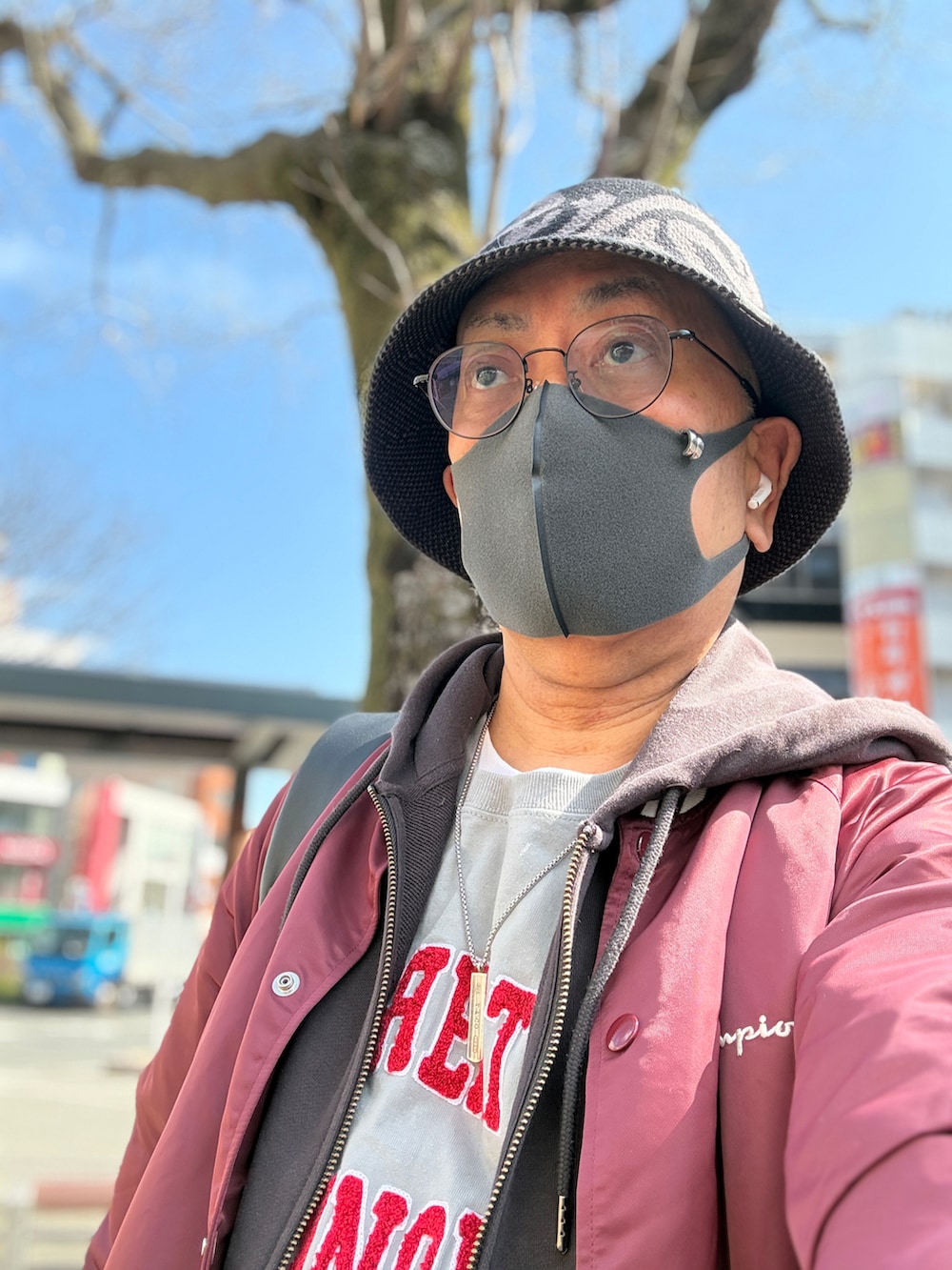 グレー系のTシャツ/カットソー、グレー系のパーカー、レッド系のナイロンジャケットを着用したメンズの春コーディネートの3枚目の写真