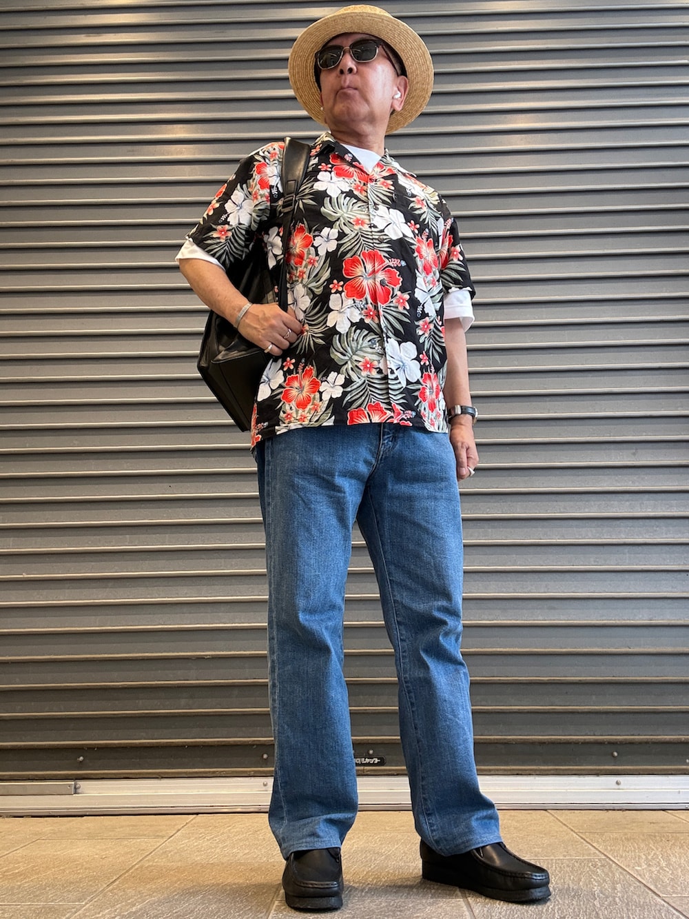 ブラック系のモカシン/デッキシューズ、ブラック系のシャツ/ブラウス、ホワイト系のTシャツ/カットソーを着用したメンズの夏コーディネートの2枚目の写真