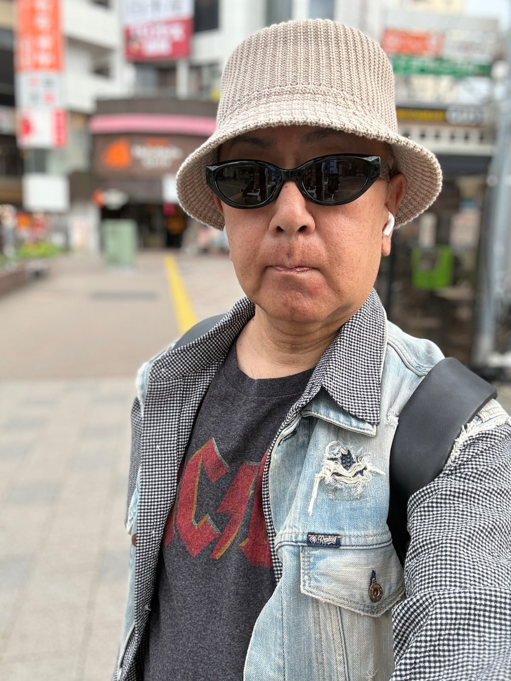 ホワイト系のスニーカー、ブルー系のベスト、ブラック系のシャツ/ブラウスを着用したメンズの春コーディネートの3枚目の写真