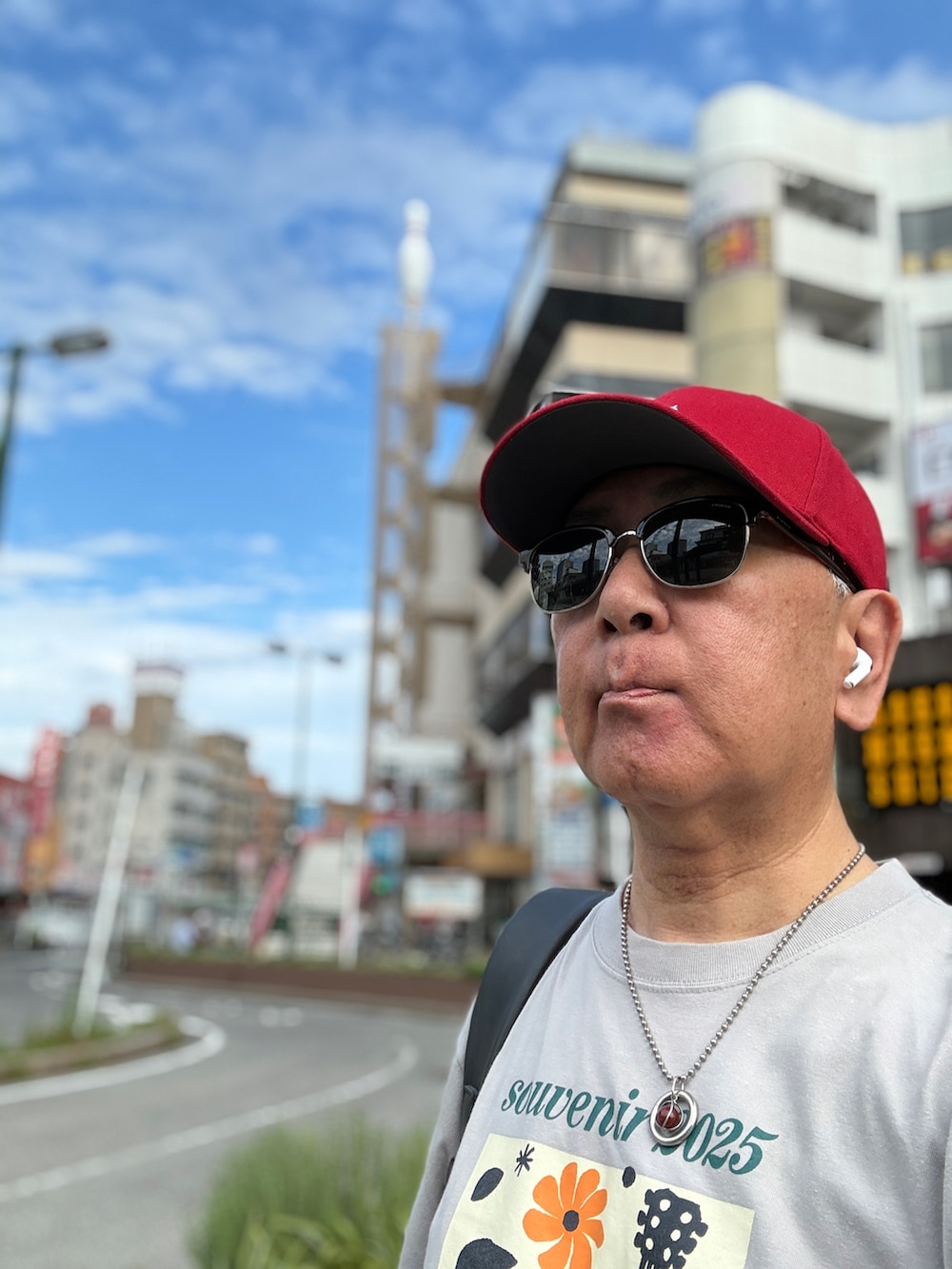 レッド系のスニーカー、グレー系のTシャツ/カットソー、ブラック系のバックパック/リュックを着用したメンズの夏コーディネートの3枚目の写真