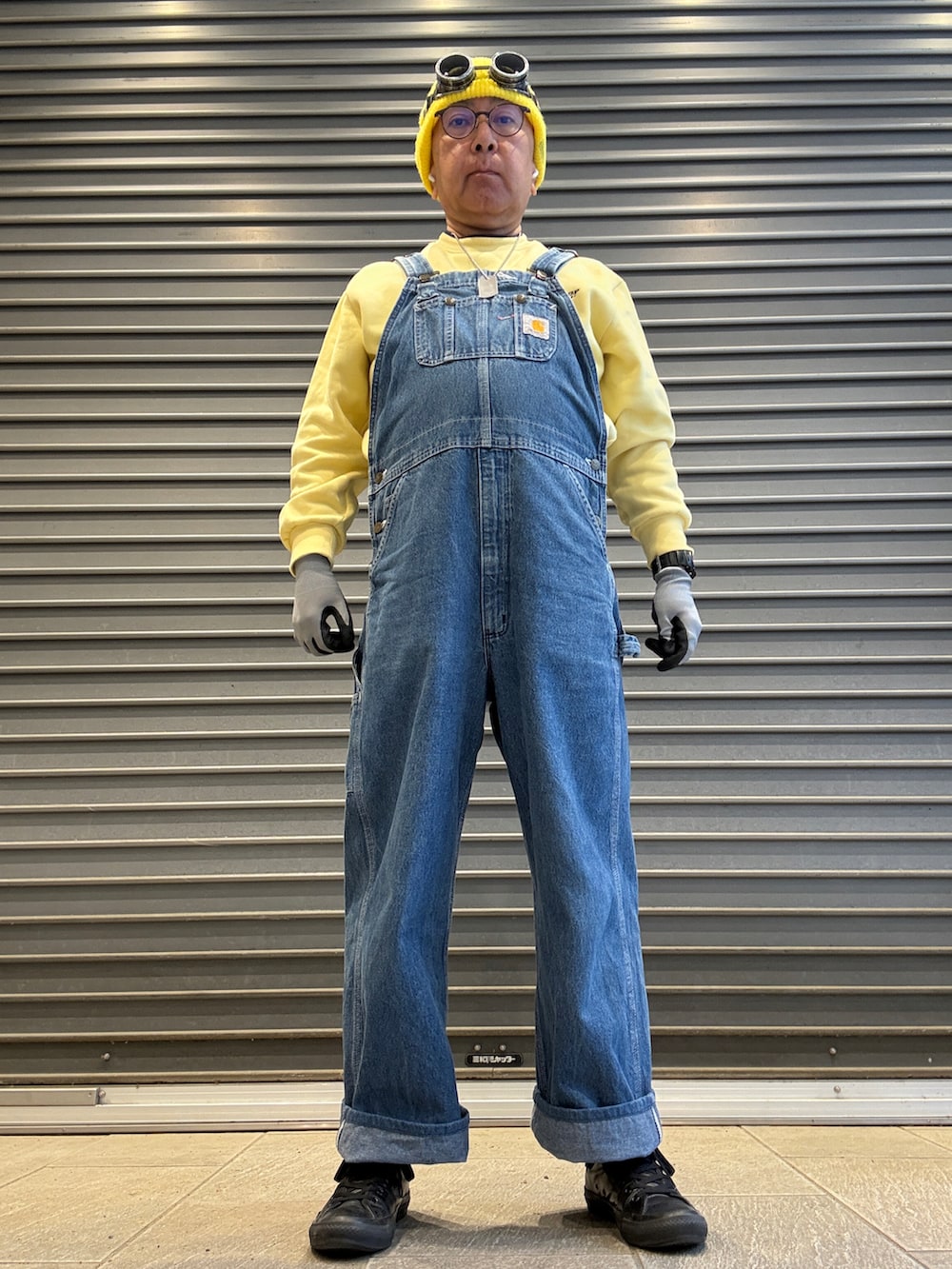 ブルー系のサロペット/オーバーオール、イエロー系のスウェット、ブラック系のスニーカーを着用したメンズの春コーディネートの2枚目の写真