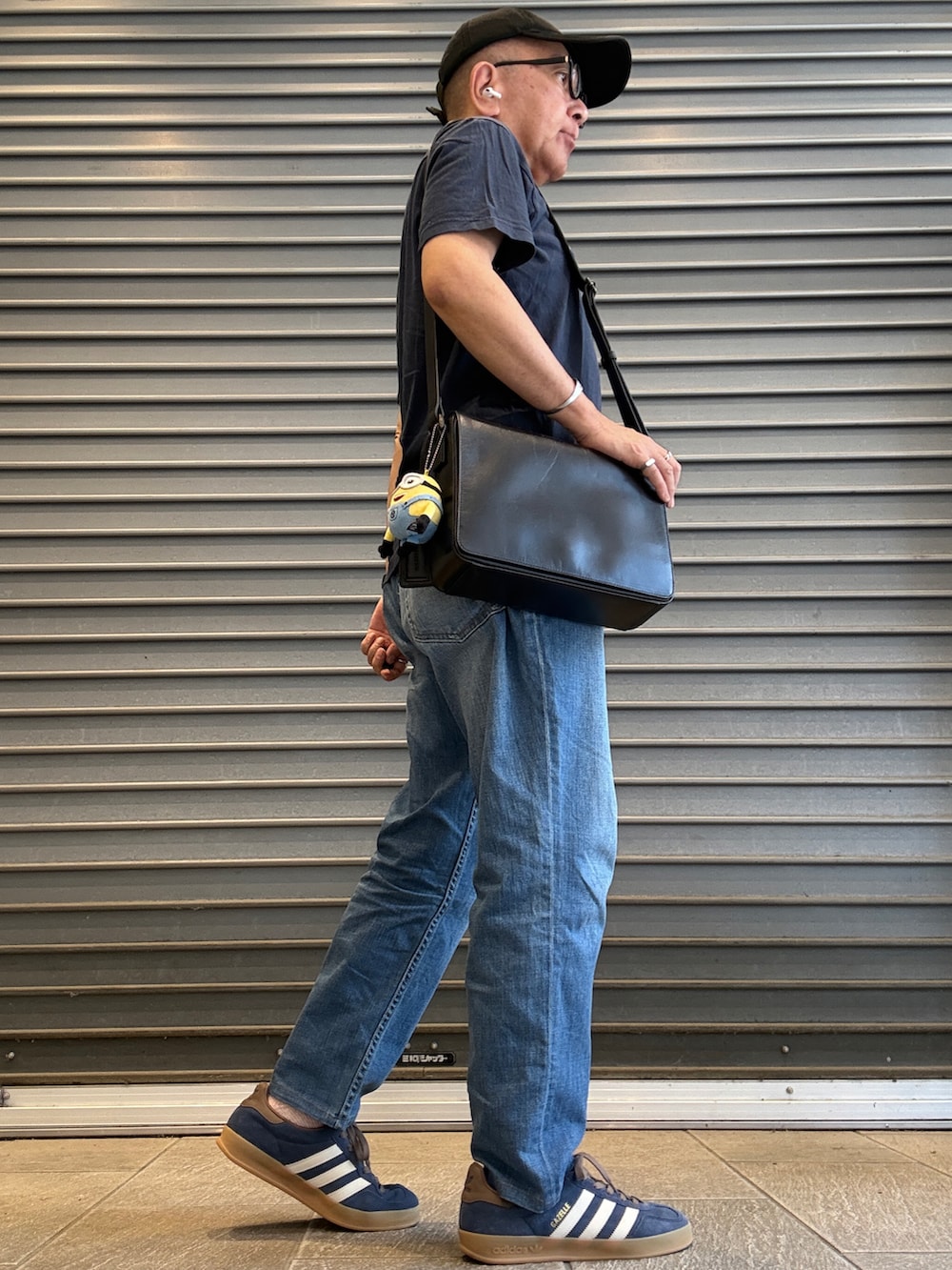 ブルー系のデニムパンツ、ブルー系のTシャツ/カットソー、ブラック系のショルダーバッグを着用したメンズの夏コーディネートの2枚目の写真