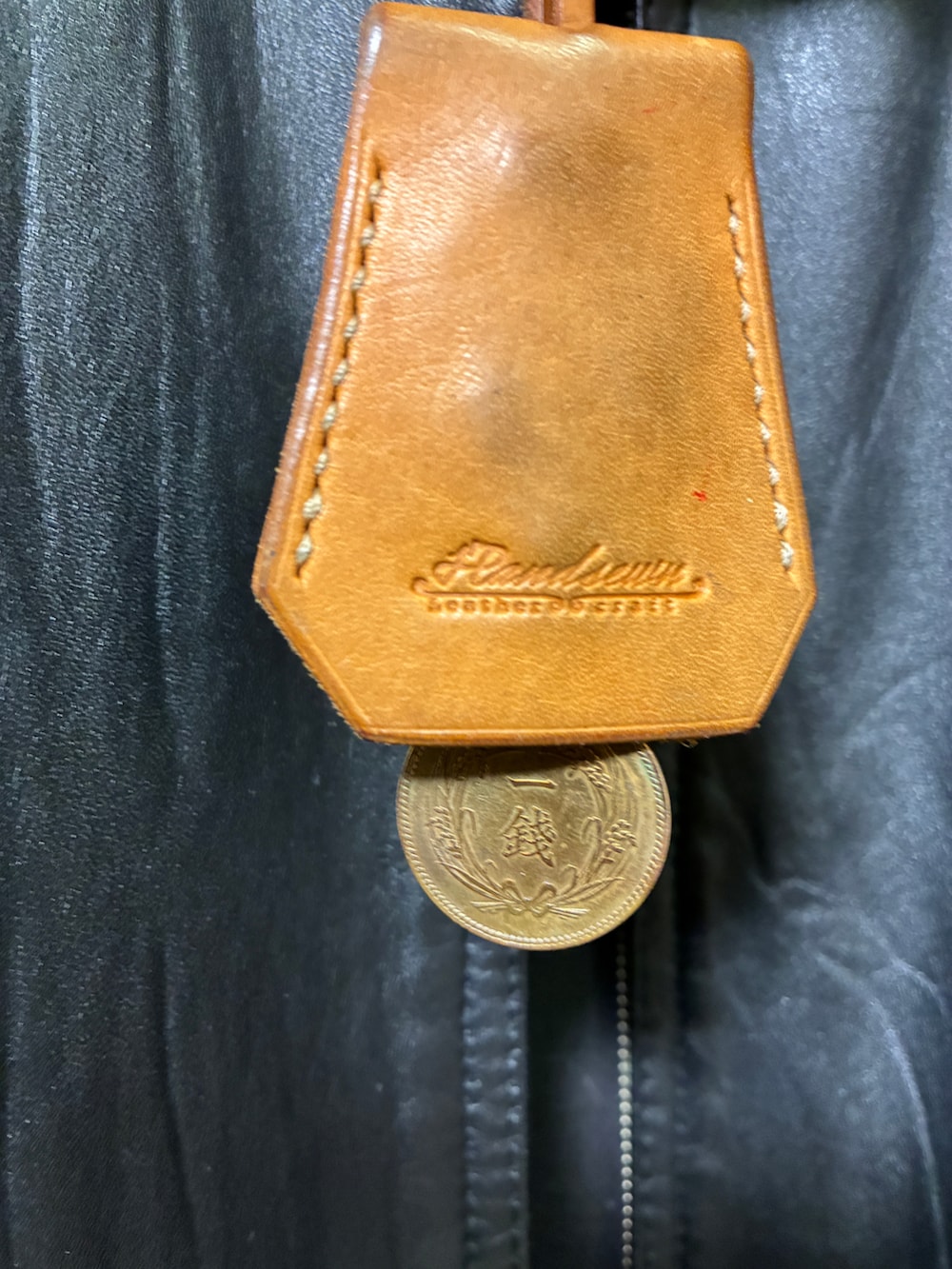 グレー系のパーカー、ブラック系のダウンジャケット/コート、レッド系のブーツを着用したメンズの冬コーディネートの2枚目の写真