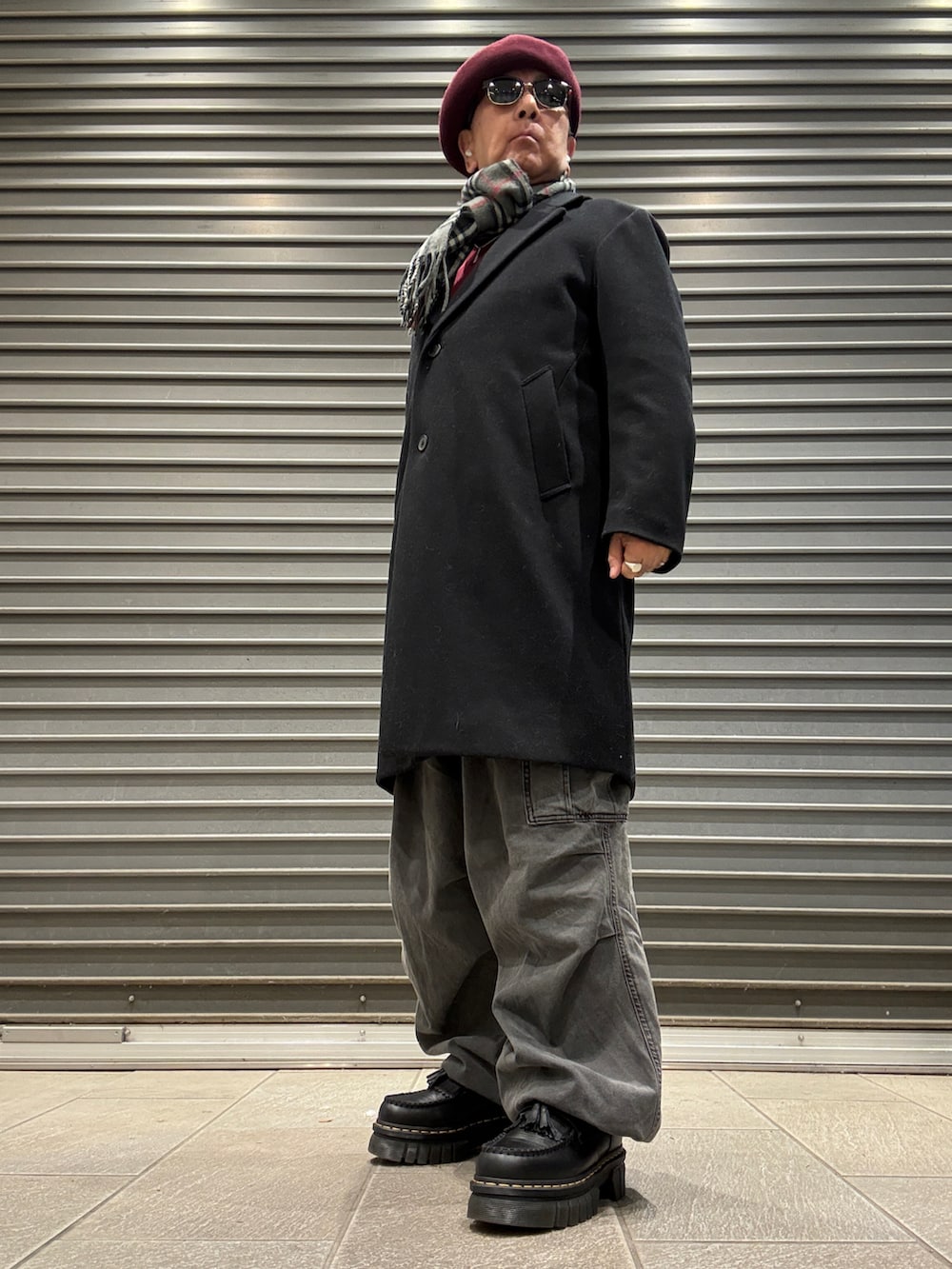 ブラック系のローファー、レッド系のスウェット、ブラック系のチェスターコートを着用したメンズの冬コーディネートの3枚目の写真