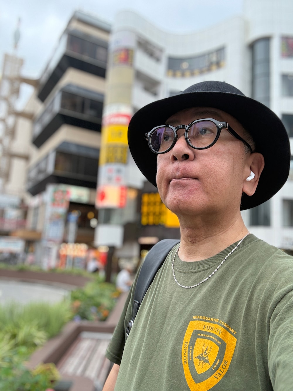ブルー系のデニムパンツ、グリーン系のTシャツ/カットソー、ブラック系のバックパック/リュックを着用したメンズの夏コーディネートの3枚目の写真