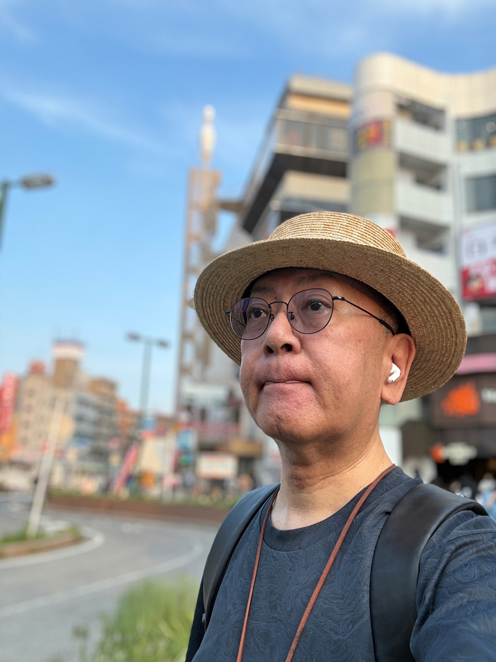 ブルー系のデニムパンツ、ブラック系のバックパック/リュック、ブルー系のTシャツ/カットソーを着用したメンズの夏コーディネートの2枚目の写真
