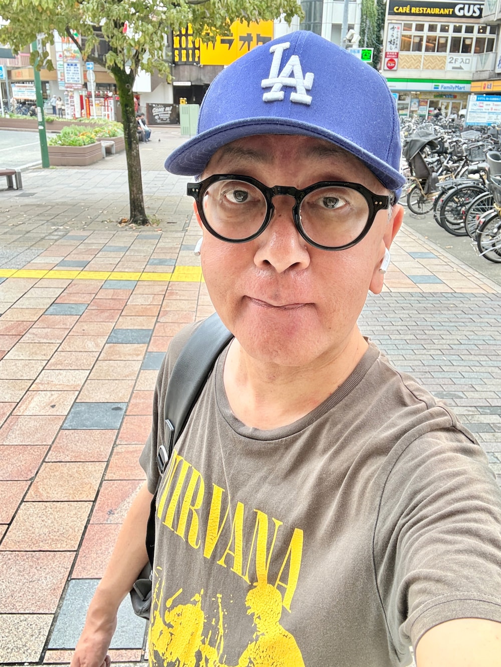 ブルー系のスニーカー、グレー系のTシャツ/カットソー、ブルー系のデニムパンツを着用したメンズの秋コーディネートの2枚目の写真