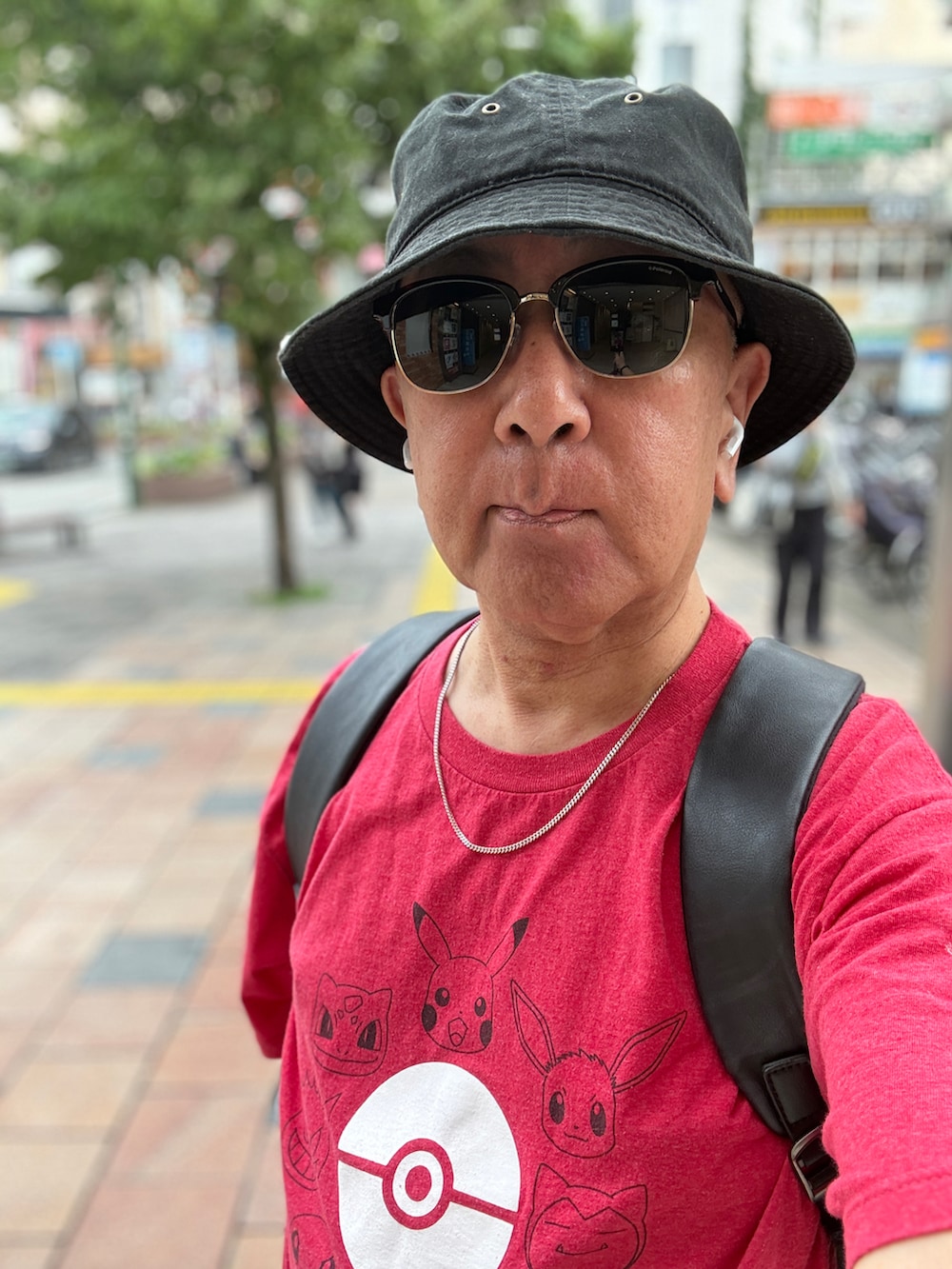 ブラック系のデニムパンツ、レッド系のTシャツ/カットソー、ブラック系のバックパック/リュックを着用したメンズの夏コーディネートの4枚目の写真