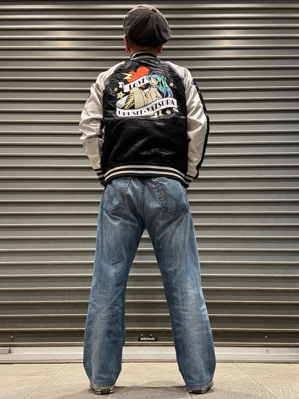 ブラック系のスカジャン、ブラック系のスニーカー、ブラック系のTシャツ/カットソーを着用したメンズの春コーディネートの2枚目の写真