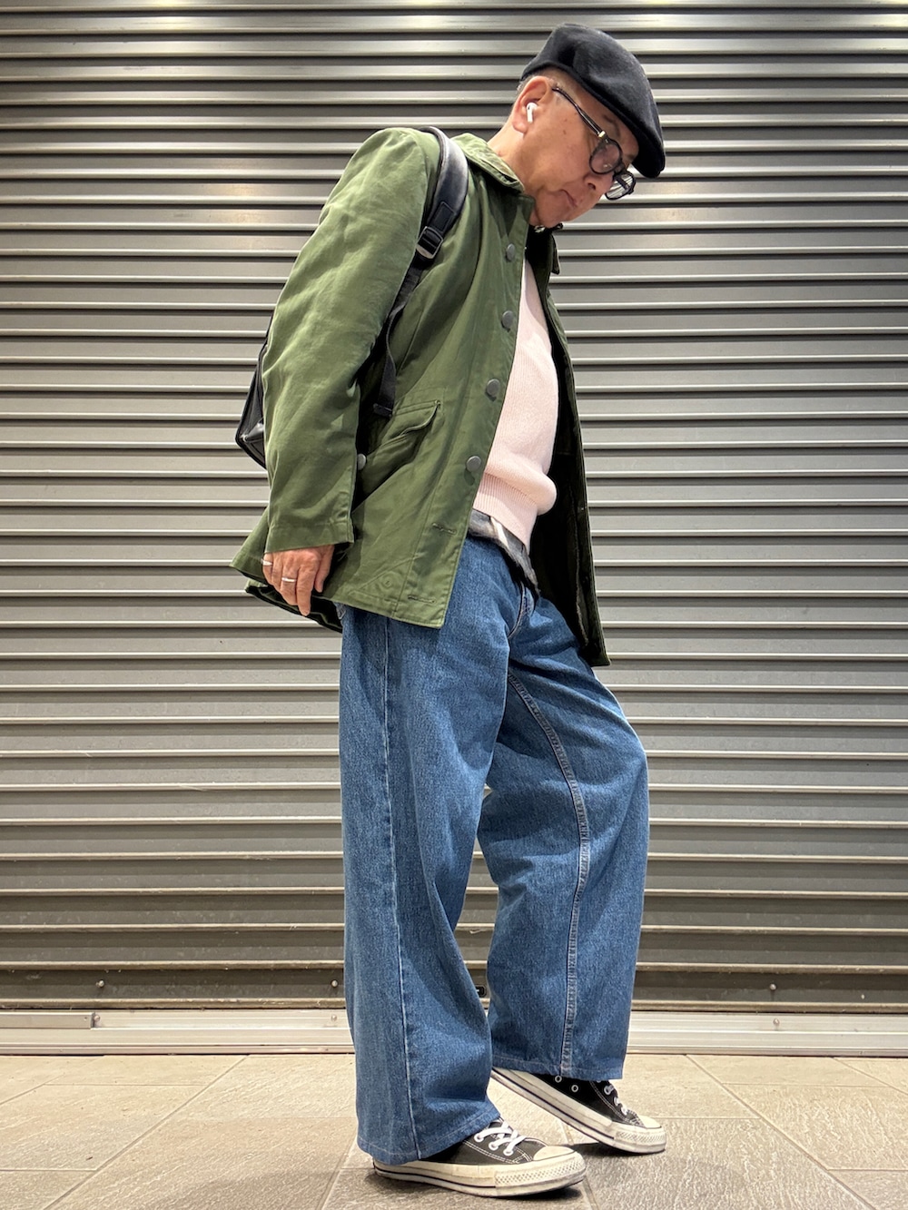 ブラック系のスニーカー、ピンク系のニット/セーター、ブラック系のシャツ/ブラウスを着用したメンズの春コーディネートの2枚目の写真