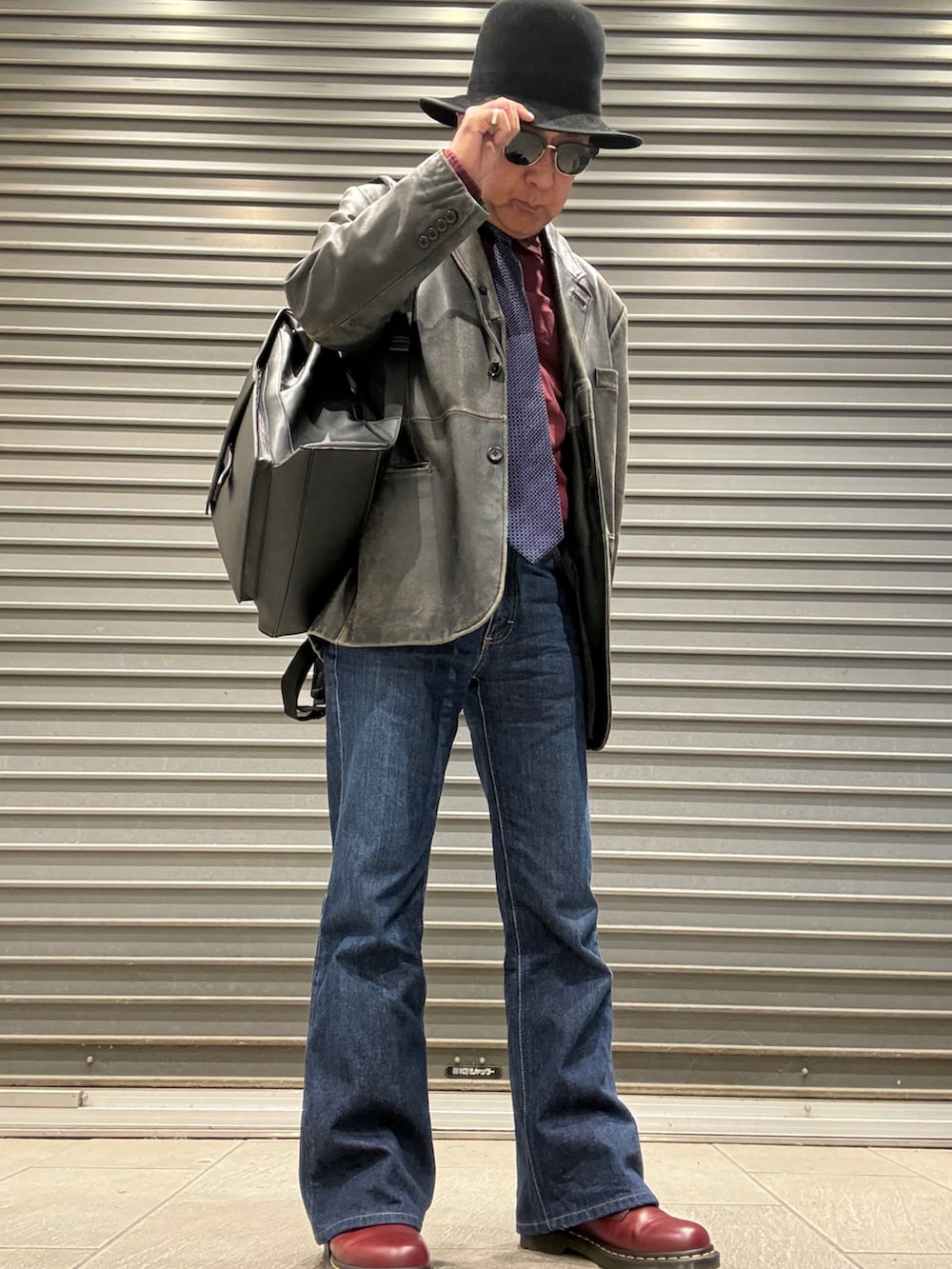 レッド系のブーツ、ブルー系のデニムパンツ、レッド系のシャツ/ブラウスを着用したメンズの秋コーディネートの2枚目の写真