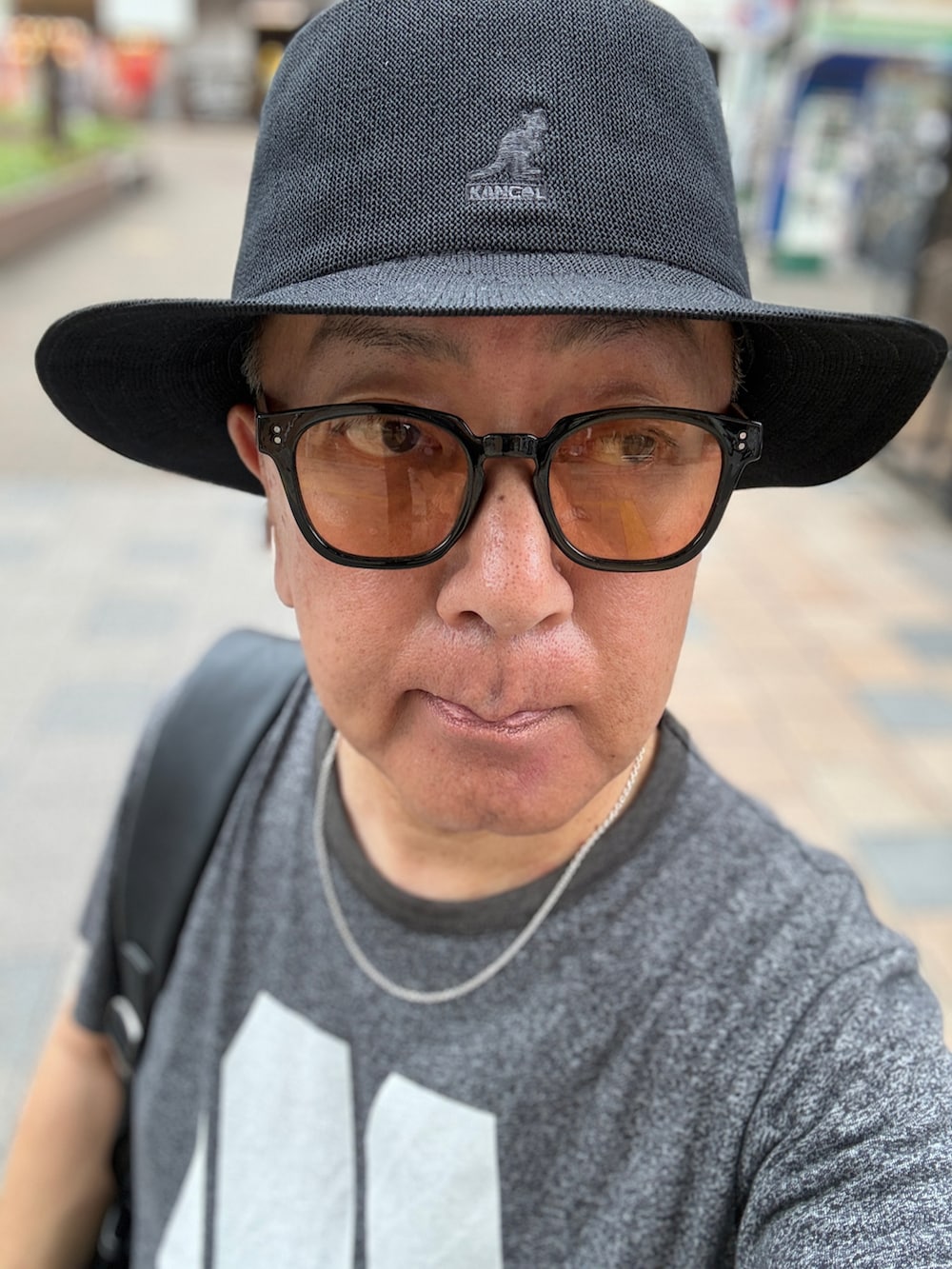 グレー系のデニムパンツ、グレー系のTシャツ/カットソー、ブラック系のバックパック/リュックを着用したメンズの夏コーディネートの3枚目の写真