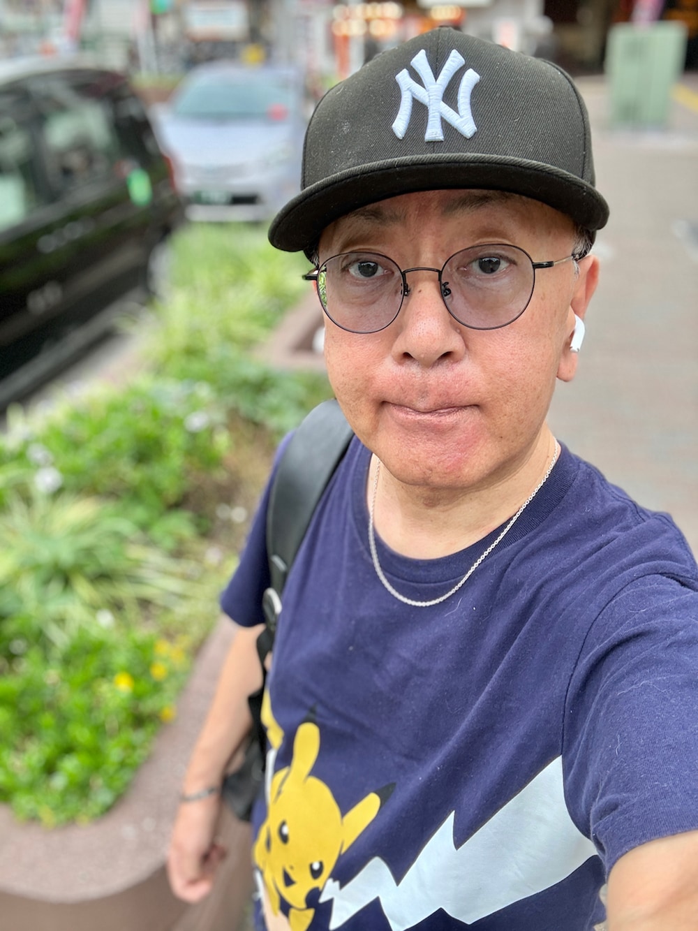 ブルー系のデニムパンツ、ブルー系のTシャツ/カットソー、ブラック系のバックパック/リュックを着用したメンズの夏コーディネートの2枚目の写真
