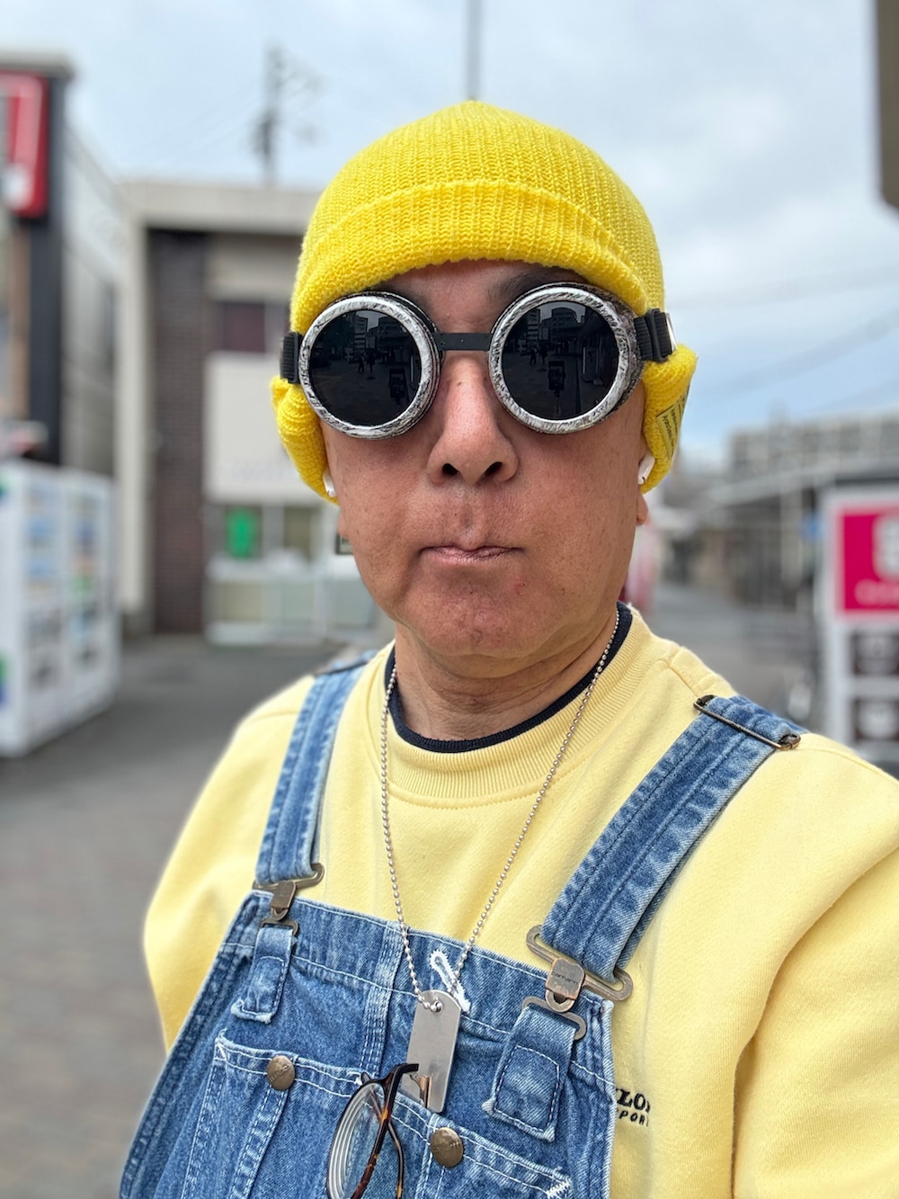 ブルー系のサロペット/オーバーオール、イエロー系のスウェット、ブラック系のスニーカーを着用したメンズの春コーディネートの5枚目の写真