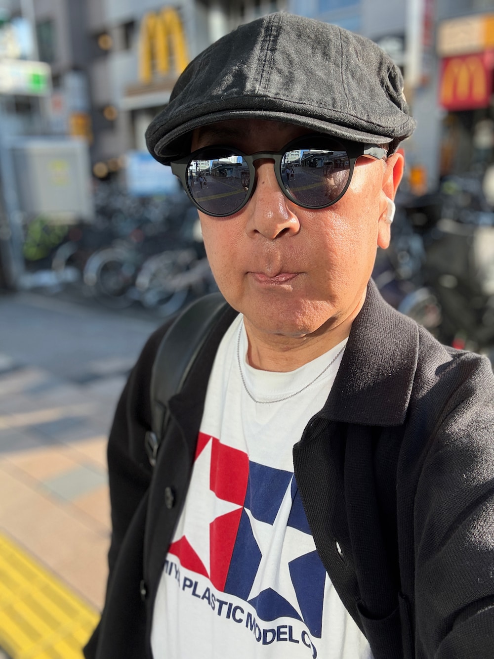 ブルー系のデニムパンツ、ホワイト系のTシャツ/カットソー、ブラック系のカーディガン/ボレロを着用したメンズの春コーディネートの2枚目の写真