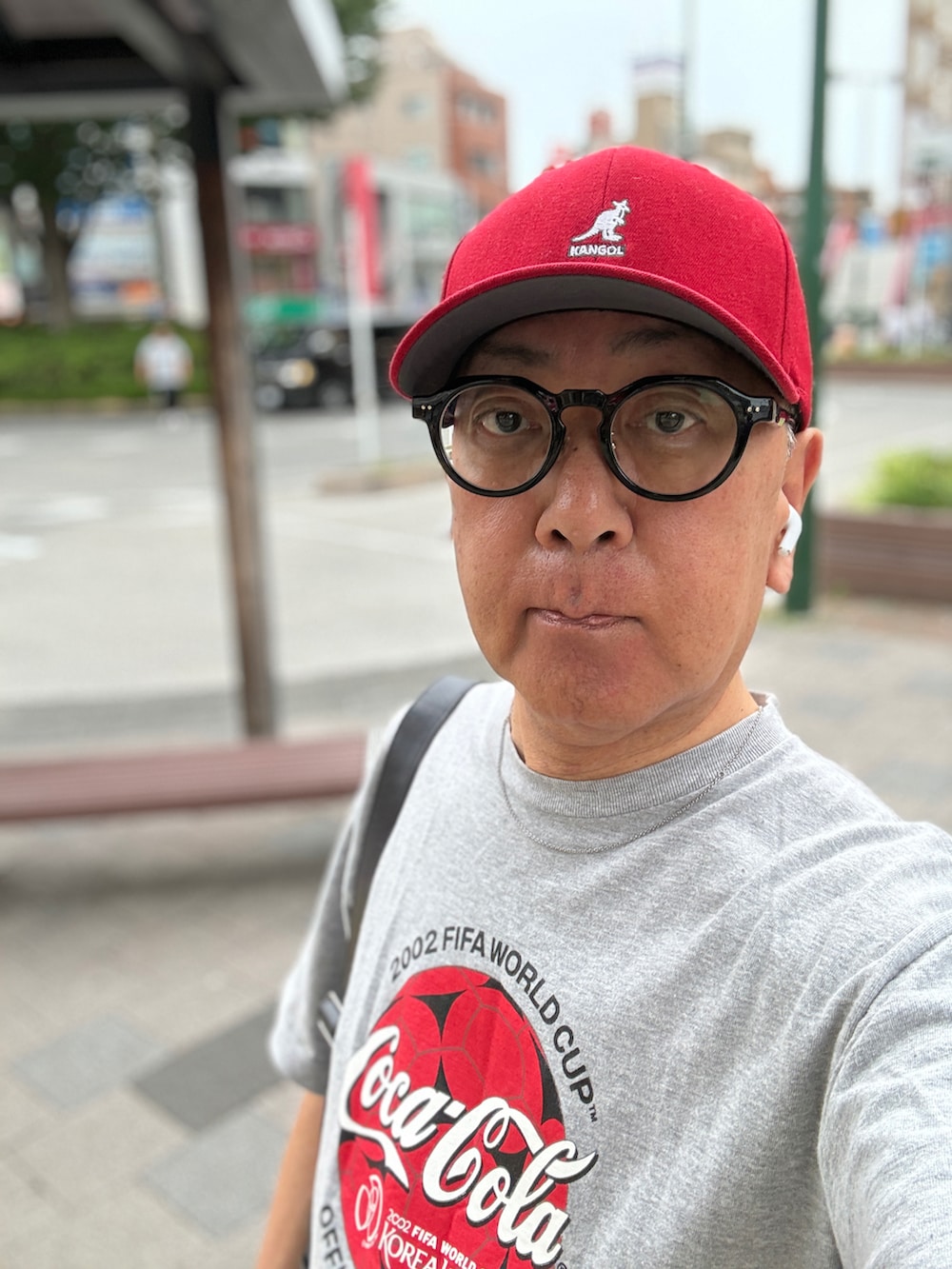 ブルー系のデニムパンツ、グレー系のTシャツ/カットソー、ブラック系のショルダーバッグを着用したメンズの夏コーディネートの4枚目の写真