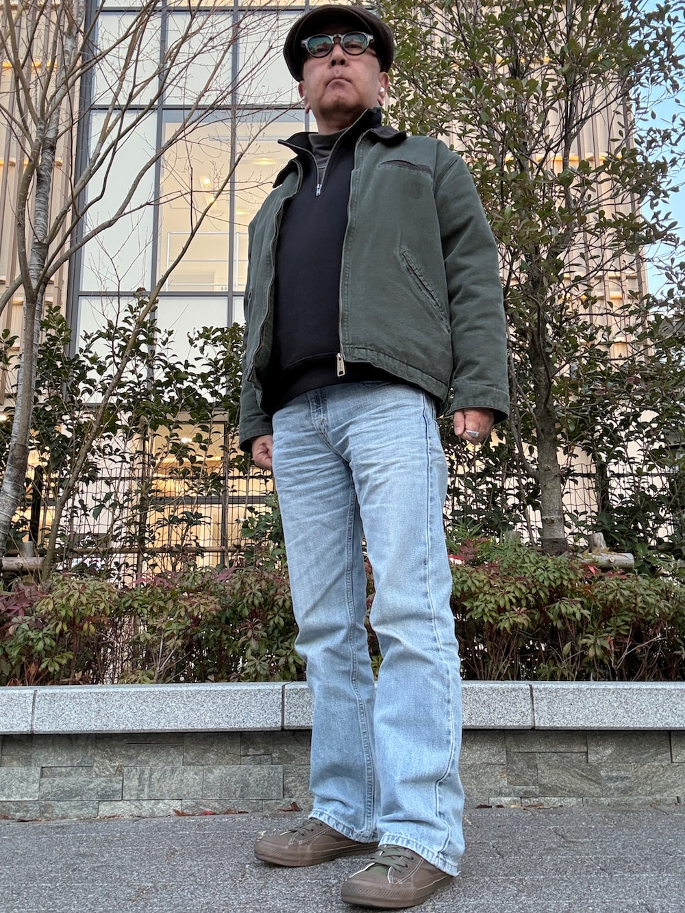 ブラック系のスウェット、グリーン系のその他アウター、ブルー系のデニムパンツを着用したメンズの冬コーディネートの3枚目の写真