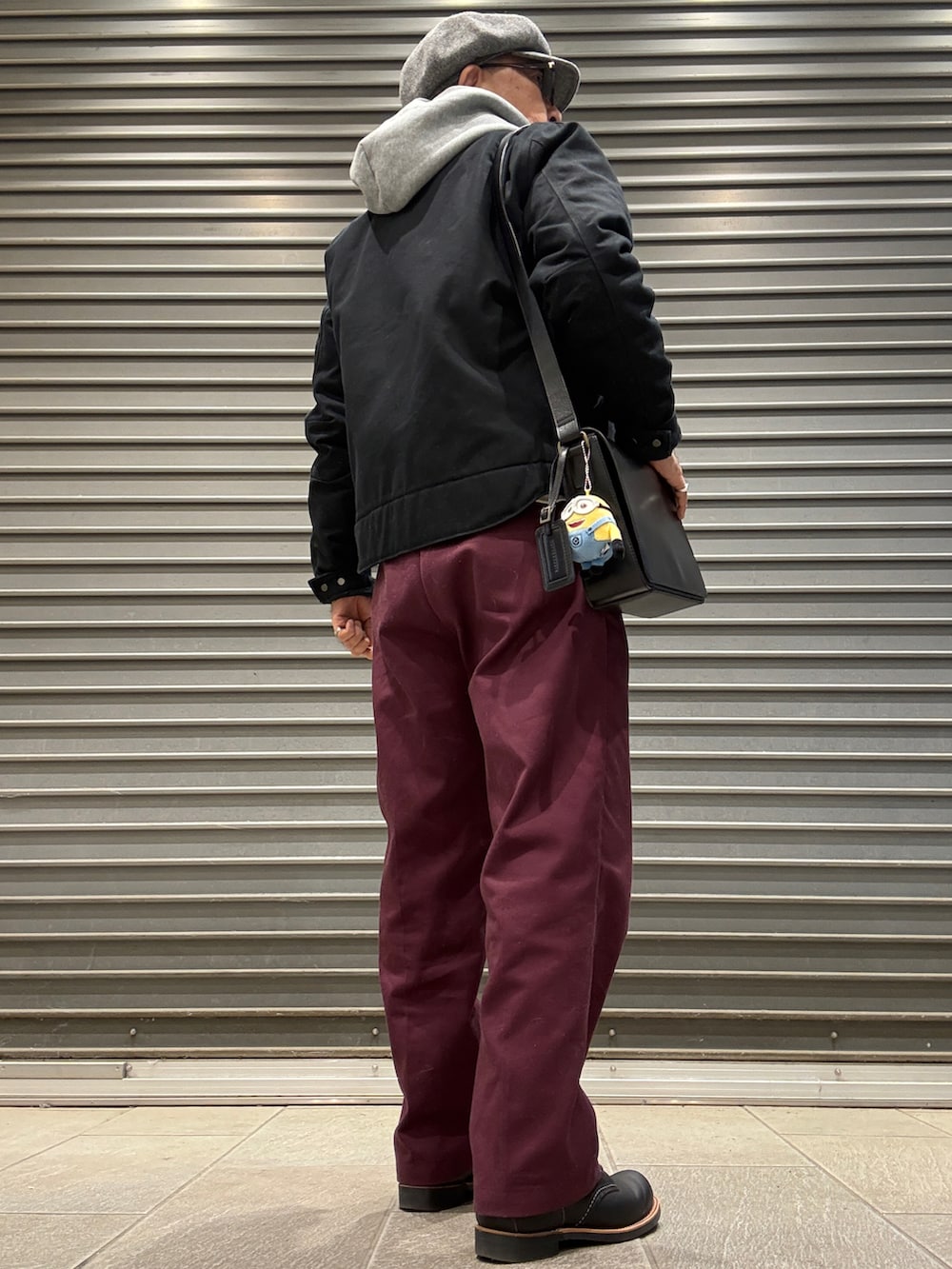 ブラック系のブーツ、ブラック系のその他アウター、レッド系のチノパンツを着用したメンズの春コーディネートの3枚目の写真