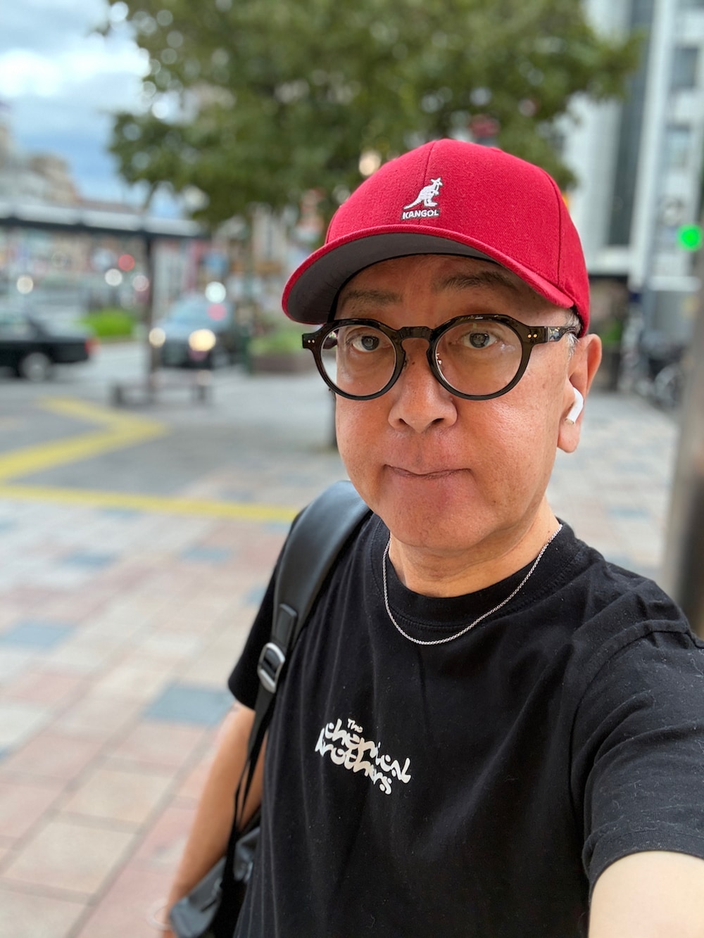 ブルー系のデニムパンツ、ブラック系のTシャツ/カットソー、ブラック系のバックパック/リュックを着用したメンズの夏コーディネートの2枚目の写真