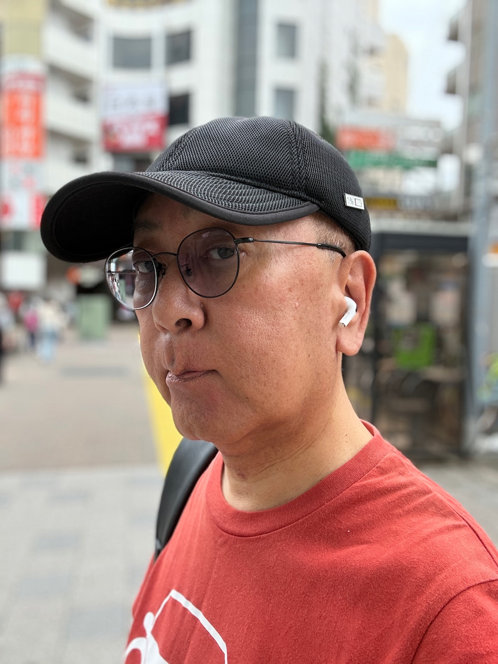 ブルー系のデニムパンツ、レッド系のTシャツ/カットソー、グレー系のスニーカーを着用したメンズの夏コーディネートの3枚目の写真