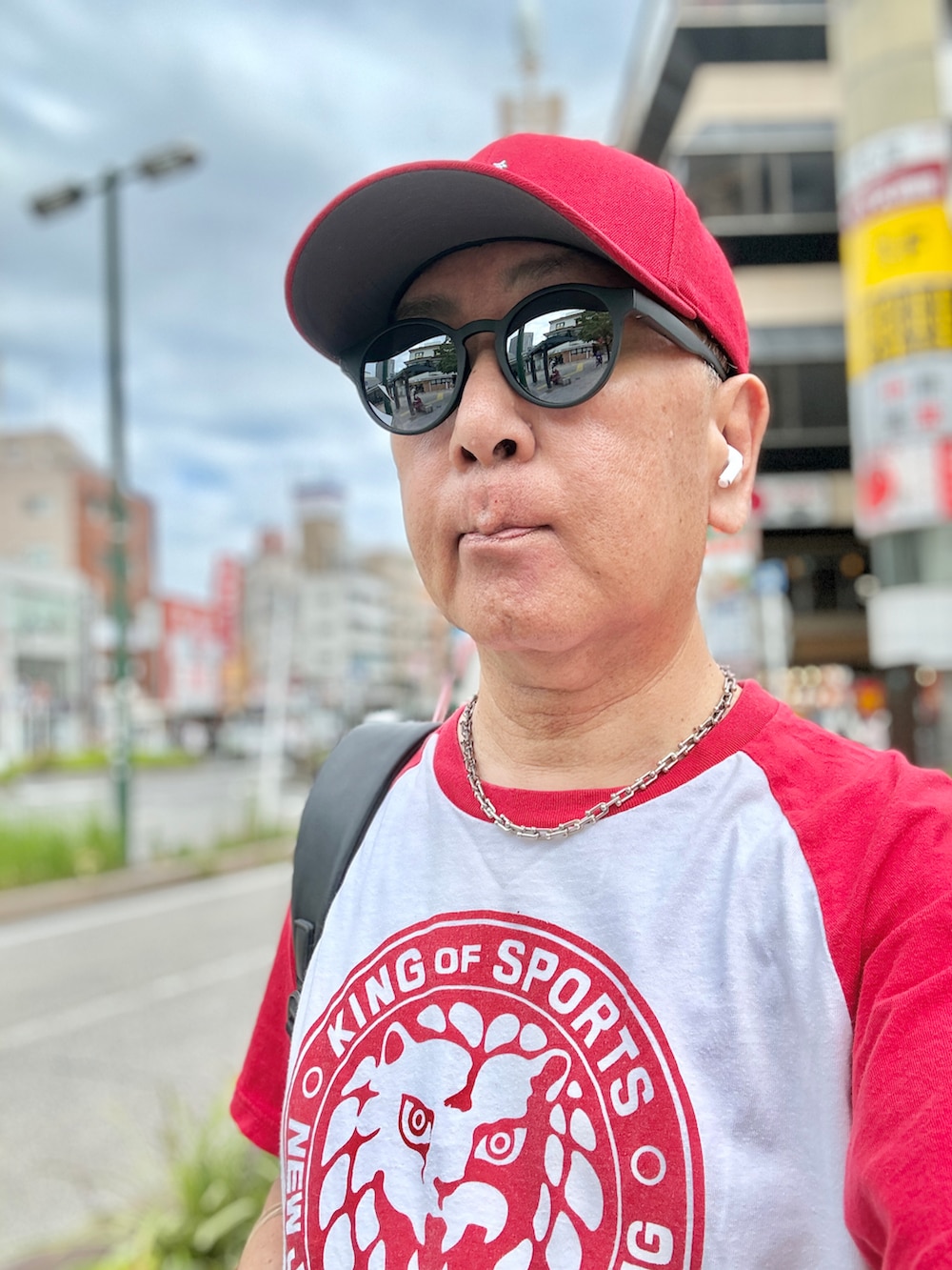 レッド系のスニーカー、ホワイト系のTシャツ/カットソー、ブラック系のバックパック/リュックを着用したメンズの夏コーディネートの3枚目の写真