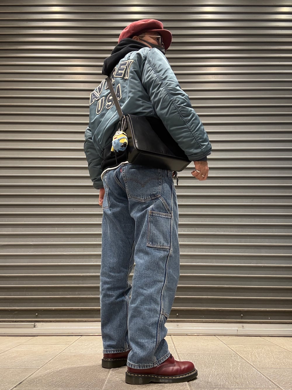 ブラック系のパーカー、レッド系のブーツ、グリーン系のMA-1を着用したメンズの春コーディネートの3枚目の写真