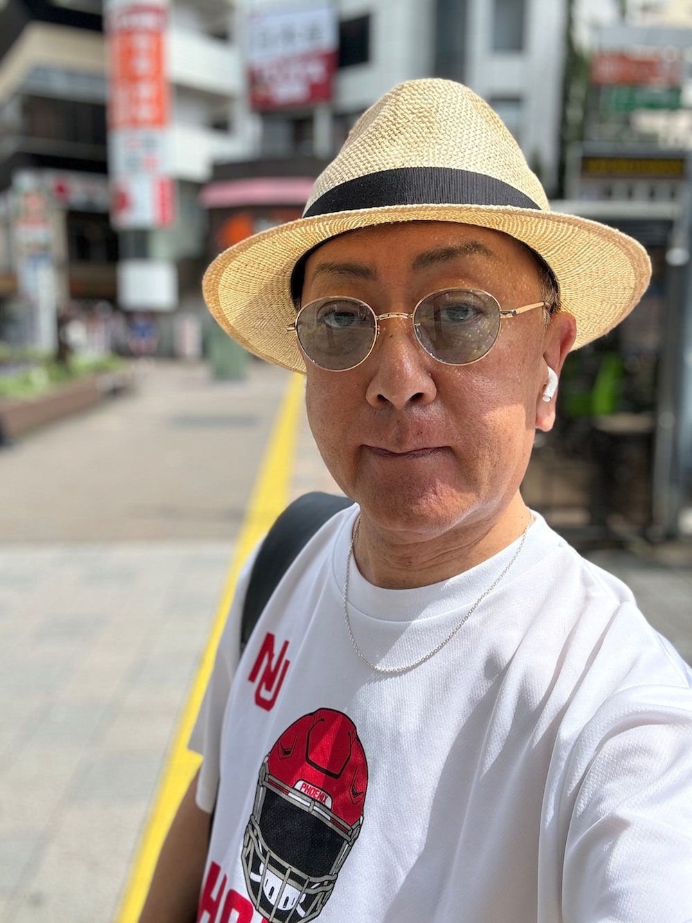 ブルー系のデニムパンツ、ブルー系のスニーカー、ホワイト系のTシャツ/カットソーを着用したメンズの夏コーディネートの2枚目の写真