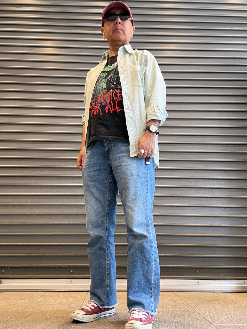 レッド系のスニーカー、グリーン系のシャツ/ブラウス、ブラック系のTシャツ/カットソーを着用したメンズの春コーディネートの2枚目の写真