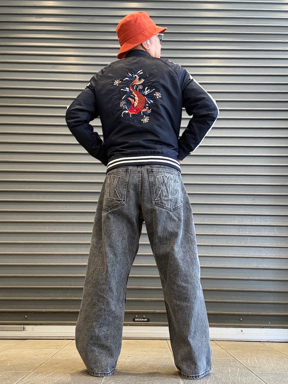 イエロー系のシャツ/ブラウス、ピンク系のニット/セーター、ブルー系のスカジャンを着用したメンズの春コーディネートの2枚目の写真