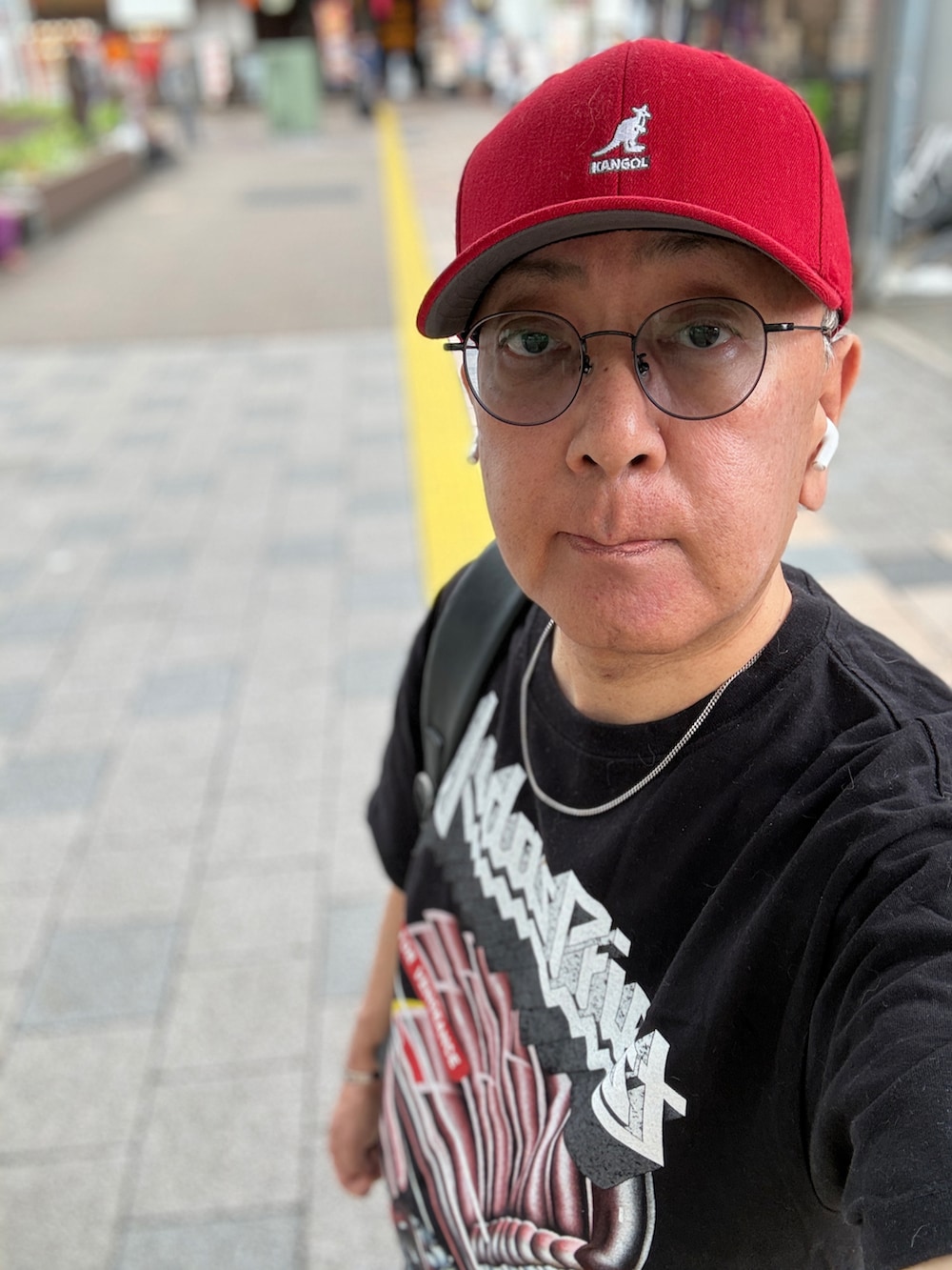 ホワイト系のスニーカー、ブラック系のTシャツ/カットソー、ブルー系のデニムパンツを着用したメンズの夏コーディネートの4枚目の写真