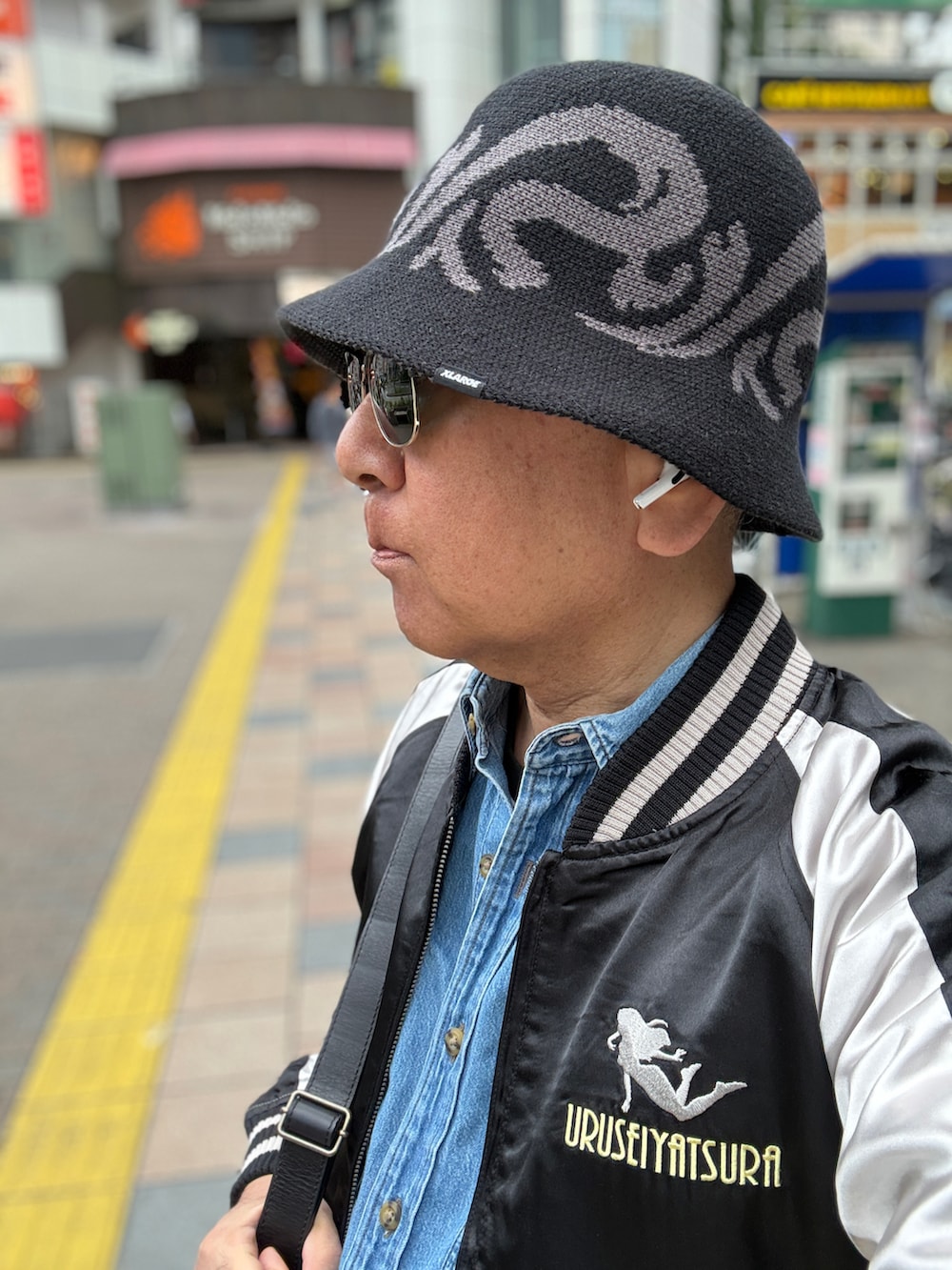 グリーン系のカーゴパンツ、ブラック系のスカジャン、ブルー系のシャツ/ブラウスを着用したメンズの春コーディネートの4枚目の写真