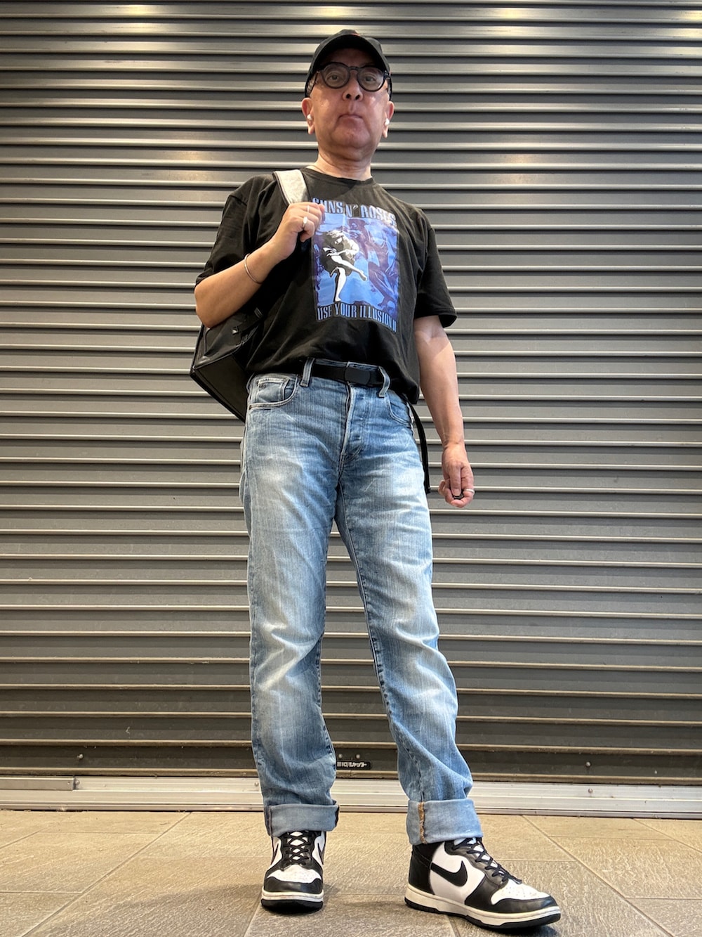 ブルー系のデニムパンツ、ブラック系のTシャツ/カットソー、ブラック系のバックパック/リュックを着用したメンズの夏コーディネートの2枚目の写真